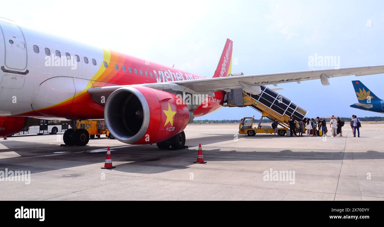 I passeggeri salgono a bordo, tramite le scale di imbarco dei passeggeri, un aereo Vietjet Air Airbus A321 all'aeroporto internazionale Tan Son Nhat, Saigon o ho chi Minh City Foto Stock
