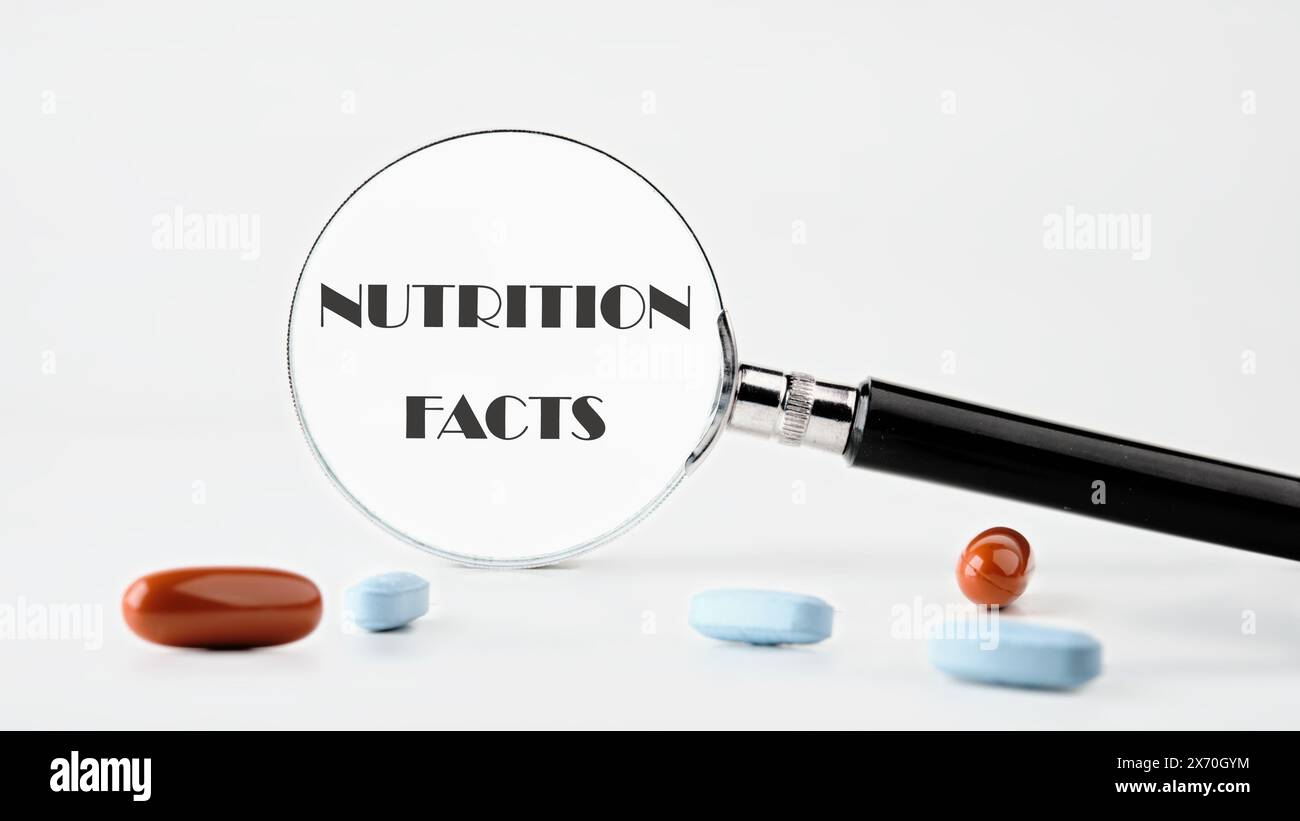 Molti fatti sulla nutrizione sono stati scritti attraverso una lente d'ingrandimento su uno sfondo chiaro. Foto concettuale Foto Stock