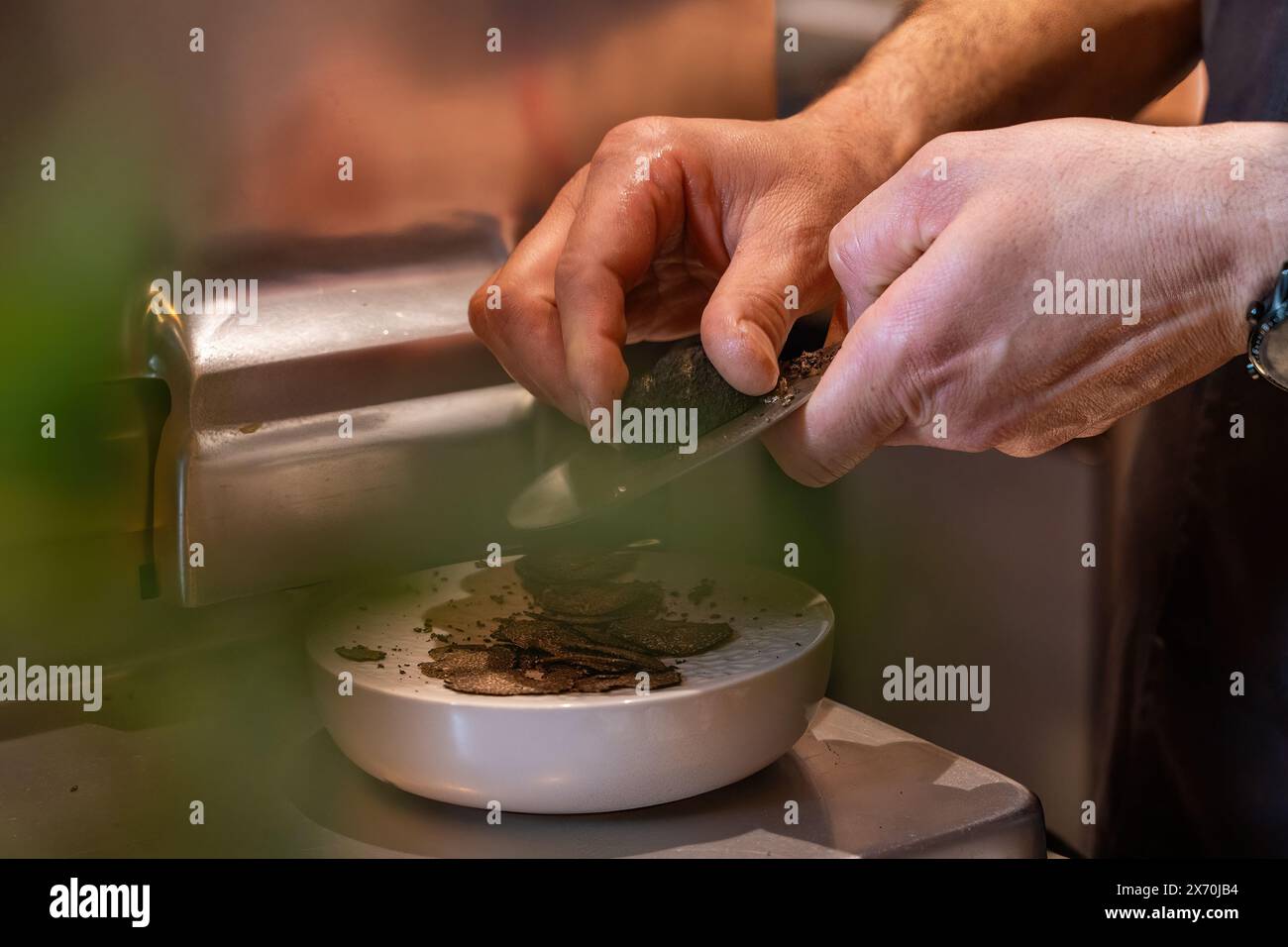 Lo chef grattugia il tartufo - prepara piatti gourmet - cucina raffinata - arte culinaria, ingredienti di lusso - ristorante di alta qualità, cucina professionale. Foto Stock