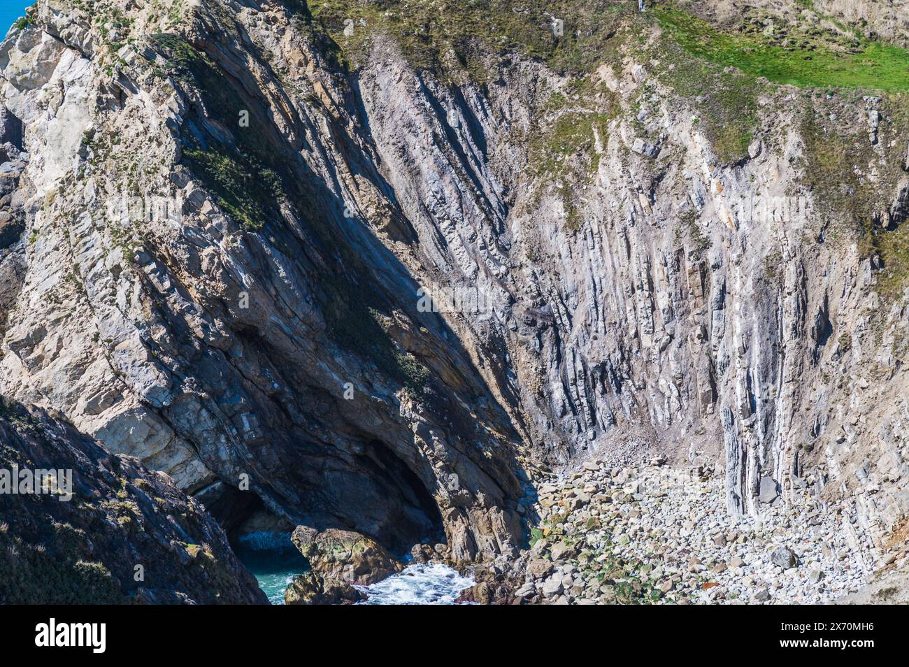 Formazione rocciosa di Lulworth a Stair Hole, Dorset, Inghilterra, in una giornata di aprile soleggiata con cielo blu e strati di calcare ripiegati Foto Stock