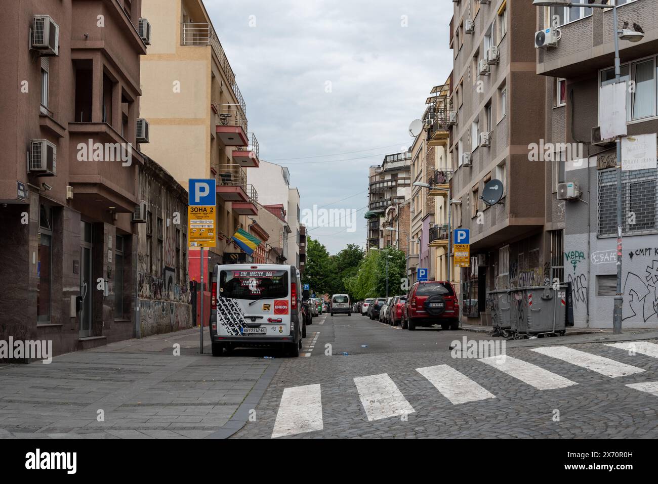Strada residenziale a Belgrado, un mix di stili di costruzione e veicoli parcheggiati. Aprile 2024. Foto Stock