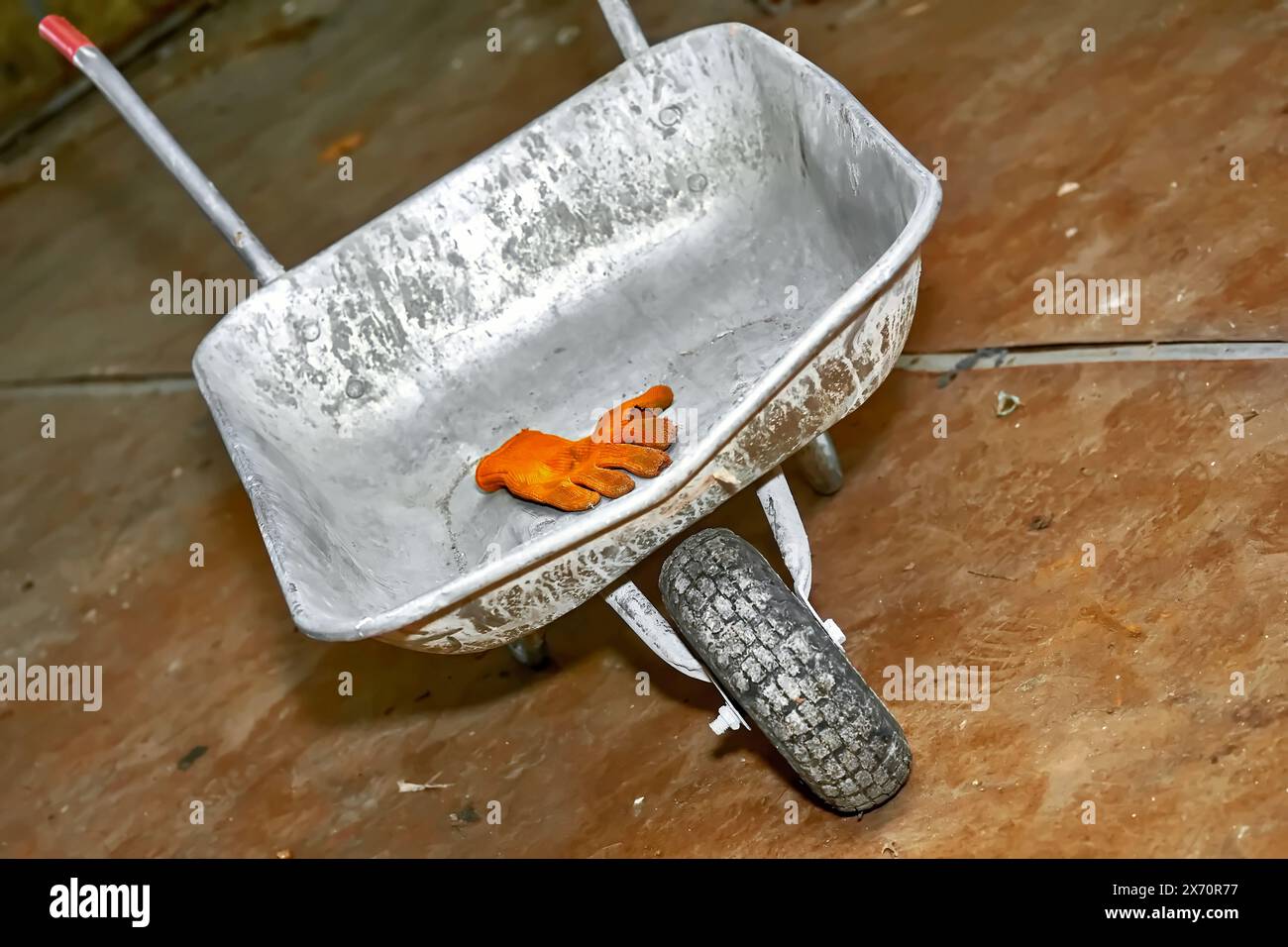 Carriola in metallo da costruzione, guanti protettivi da lavoro Foto Stock