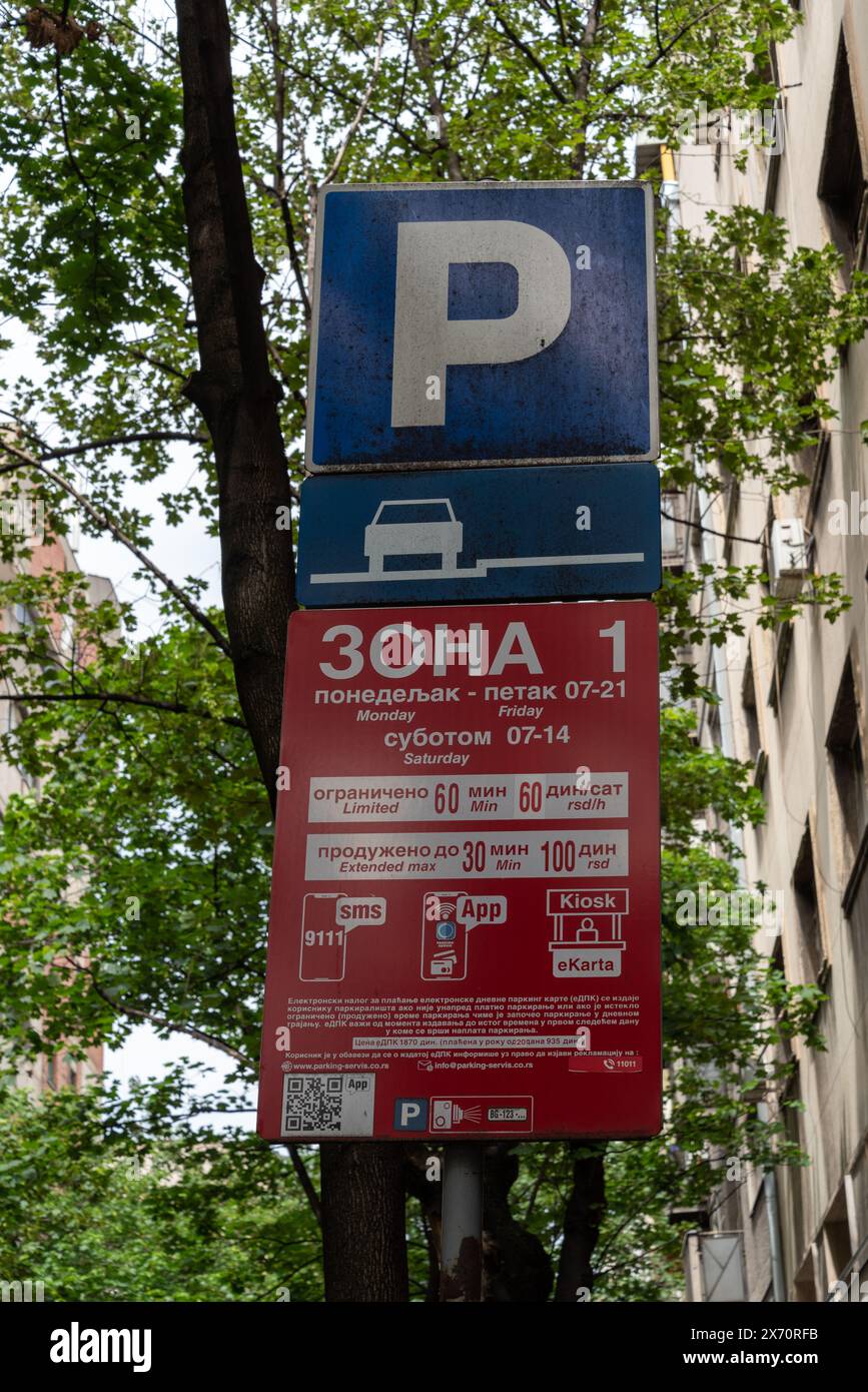 Cartello di parcheggio per le strade di Belgrado, dettagli sulle tariffe, come pagare utilizzando un testo o un'app scritta in serbo. Maggio 2024. Foto Stock
