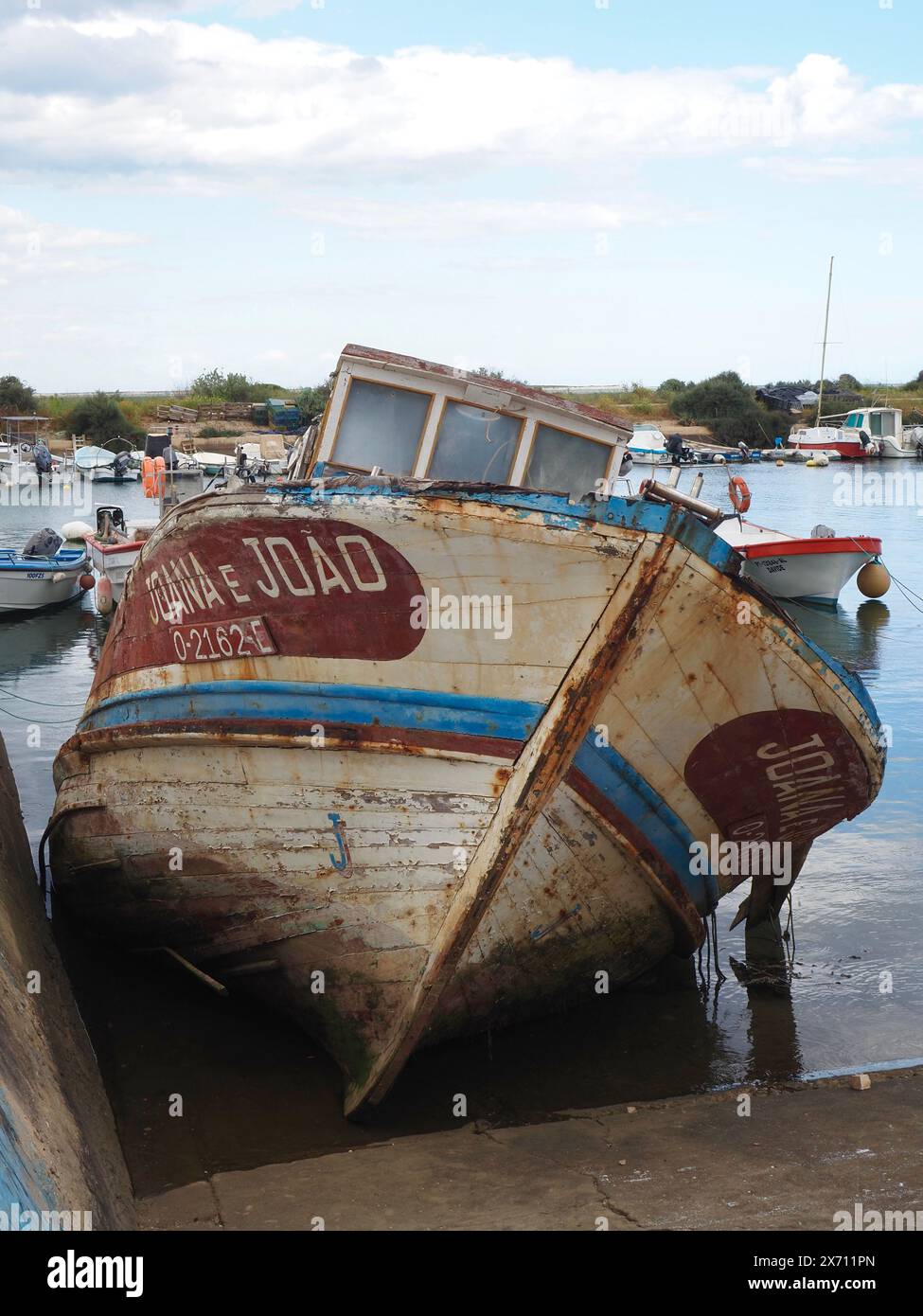 Barca abbandonata e parzialmente sommersa Joana e Joao nel porto turistico di Fuseta (Fuzeta) nell'Algarve in Portogallo Foto Stock