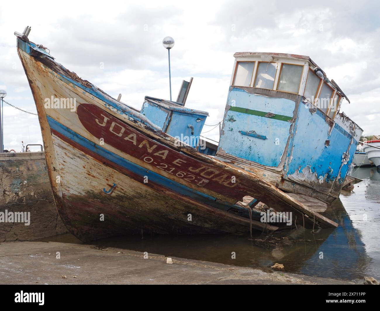 Barca abbandonata e parzialmente sommersa Joana e Joao nel porto turistico di Fuseta (Fuzeta) nell'Algarve in Portogallo Foto Stock