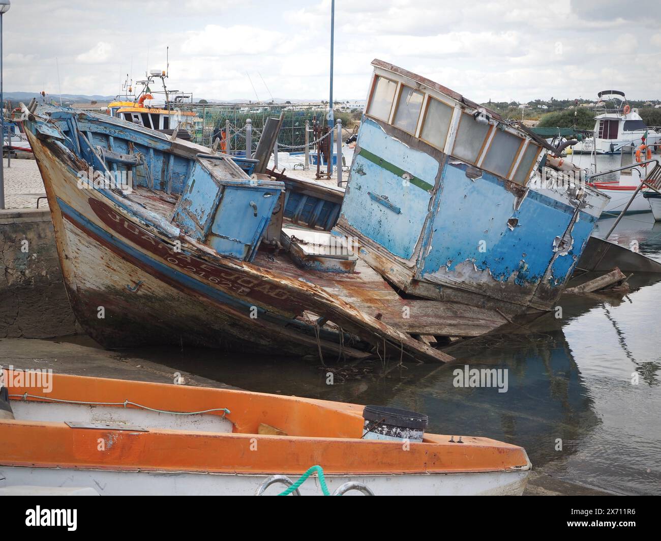 Barca abbandonata e parzialmente sommersa Joana e Joao nel porto turistico di Fuseta (Fuzeta) nell'Algarve in Portogallo Foto Stock