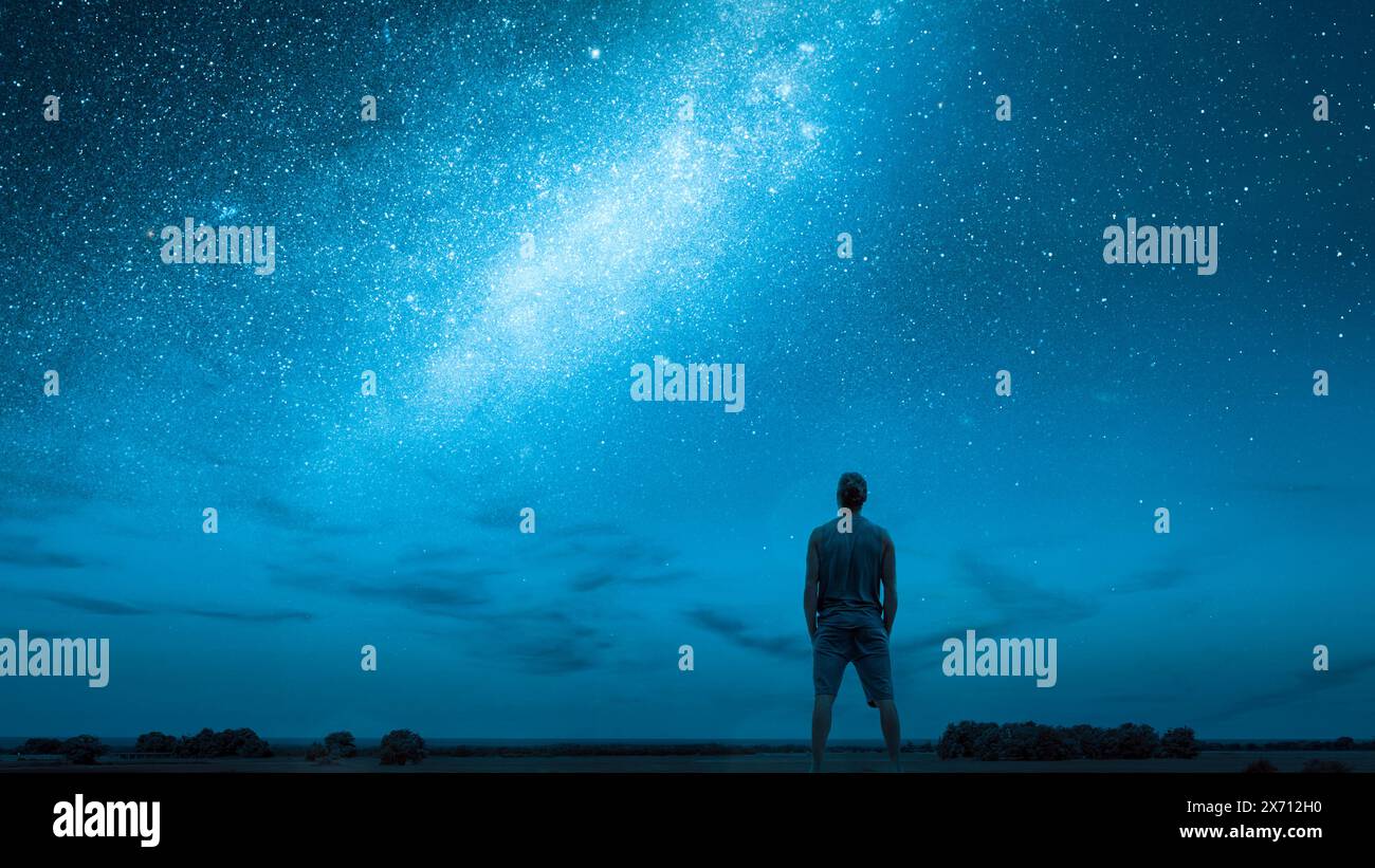 Persona che guarda le stelle sotto un cielo stellato con la via Lattea Foto Stock