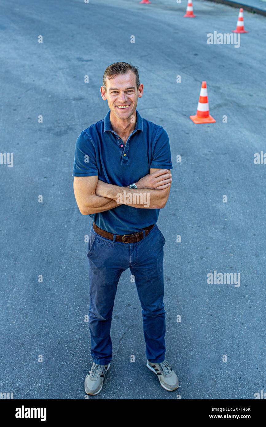 Uomo in piedi con coni stradali all'aperto Foto Stock