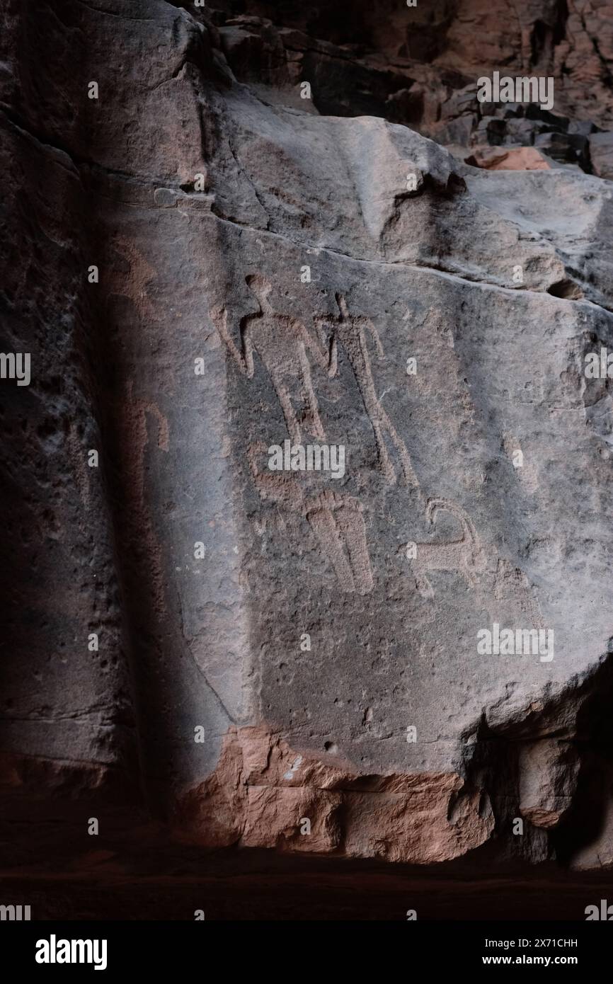 Wadi Rum, Giordania - antichi disegni artistici Thamudici e Nabatei al Siq Khazali includono forme umane, stambecchi e un paio di piedi umani Foto Stock