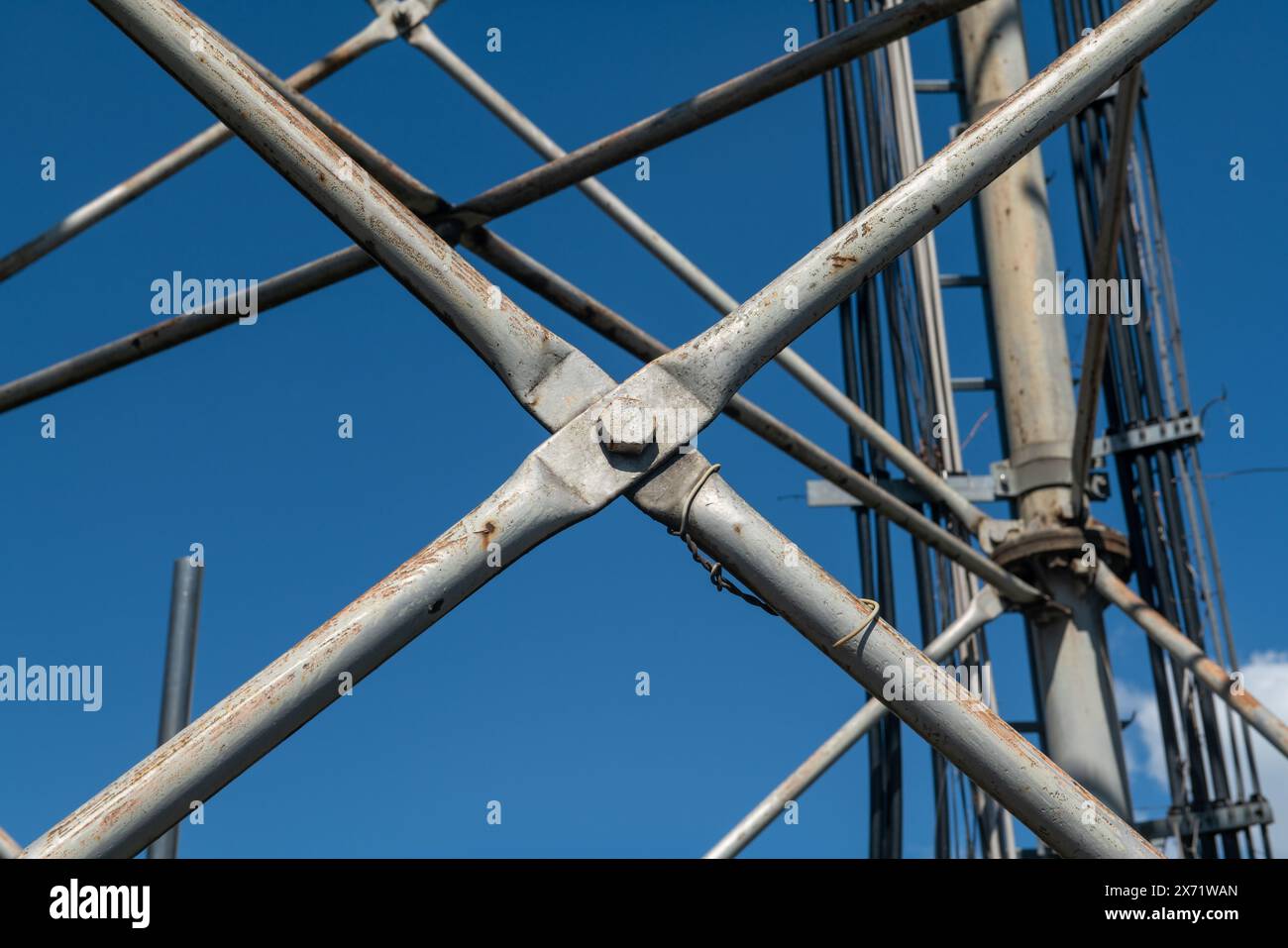 Dettagli in traliccio in acciaio, struttura reticolare di un'antenna ripetitore per bande radio, telefoniche e di comunicazione. Tiranti e dadi in acciaio inox. Foto Stock