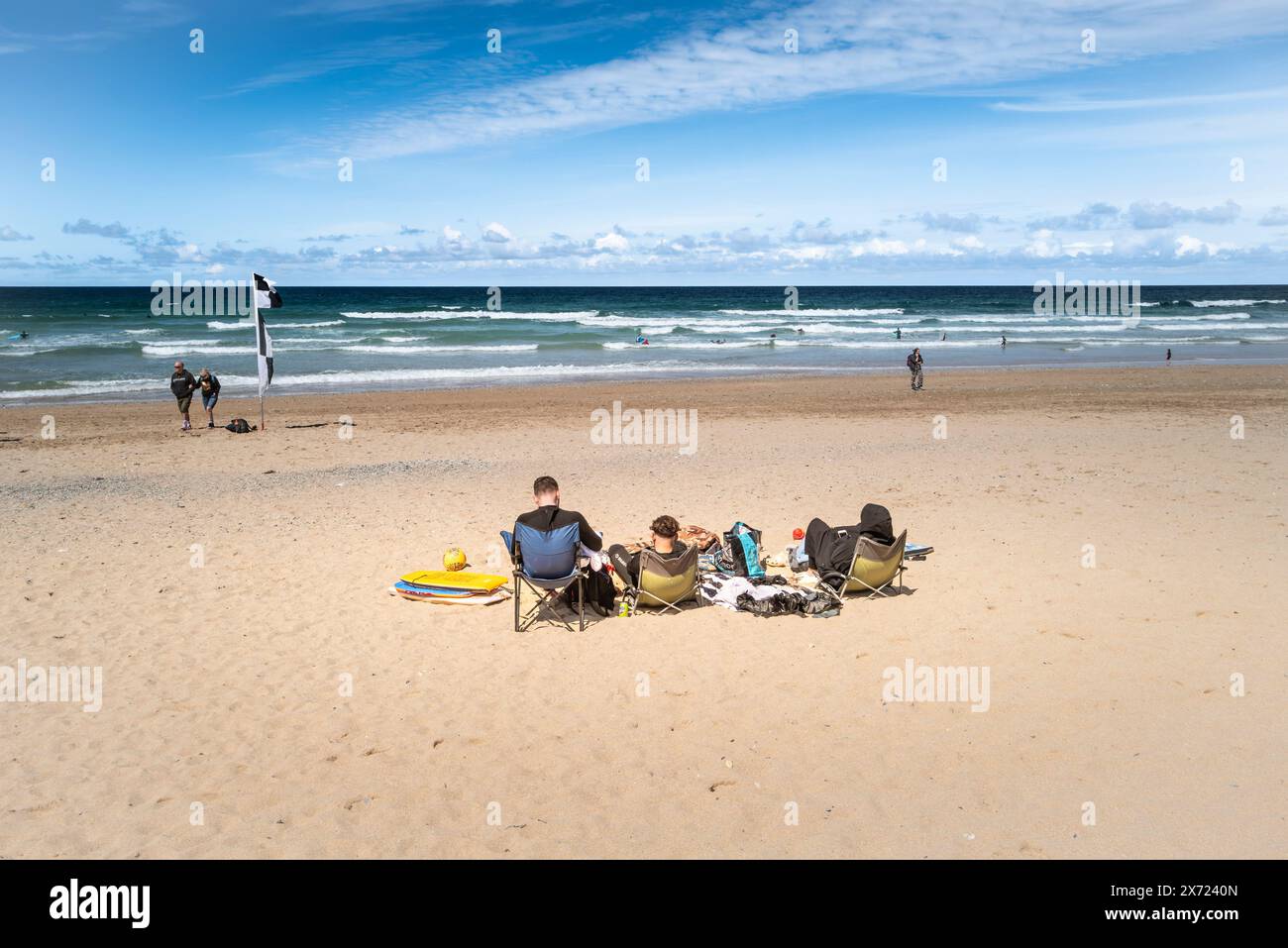 I turisti si rilassano a Fistral Beach a Newquay in Cornovaglia nel Regno Unito. Foto Stock