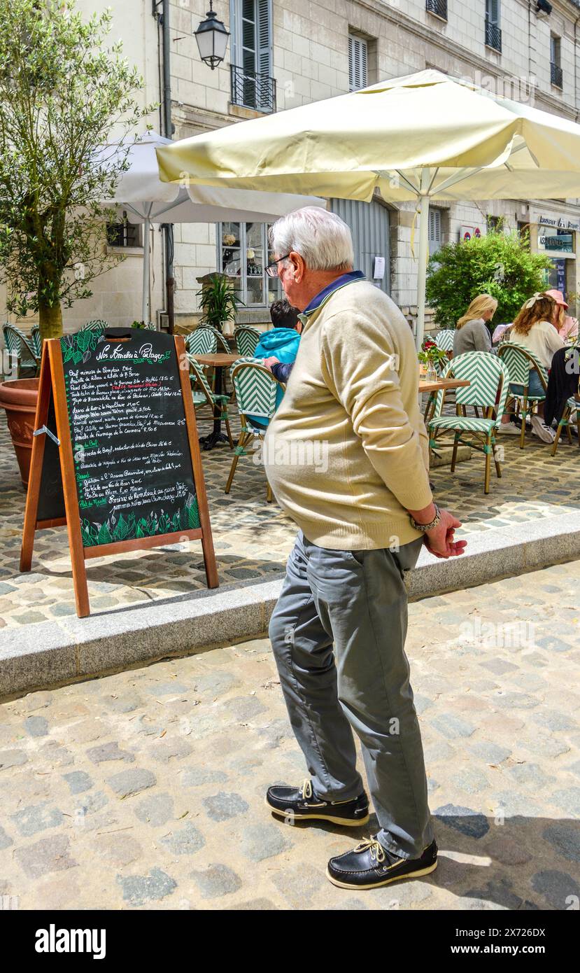 Uomo in sovrappeso che guarda al menu del ristorante - Loches, Indre-et-Loire (37), Francia. Foto Stock
