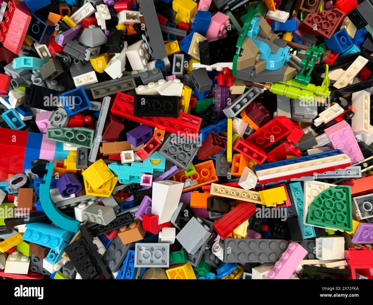 Grande scatola di mattoni Lego con parti miste tra cui porte, ruote e altri oggetti. Foto Stock
