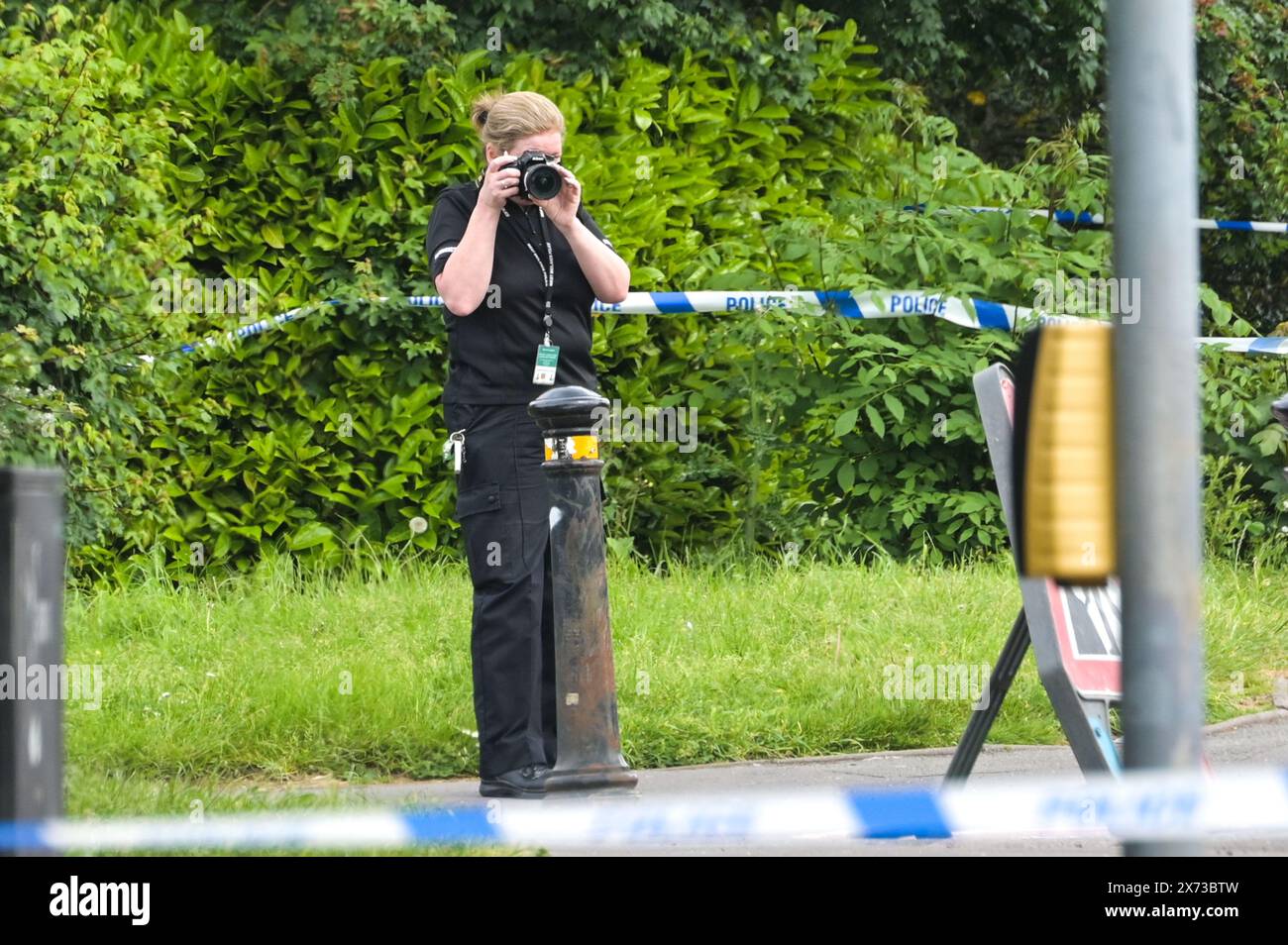 Clevedon Road, Birmingham, 17 maggio 2024 - la polizia di West Midlands ha chiuso diverse strade nella zona di Balsall Heath di Birmingham dopo che un inseguimento della polizia ha portato il conducente in fuga di una Nissan Micra a schiantarsi contro un altro veicolo. Un occupante maschio della Micra è stato gravemente ferito e portato in ospedale in arresto. Altri due uomini sono fuggiti dalla scena, uno è stato arrestato poco tempo dopo e l'altro è eccezionale. Gli agenti inondarono l'area di Clevedon Road e Lincoln Street creando un grande cordone. Un allenatore da uomo e una giacca nera insieme al pronto soccorso possono essere visti sulla strada da un passaggio pedonale Foto Stock