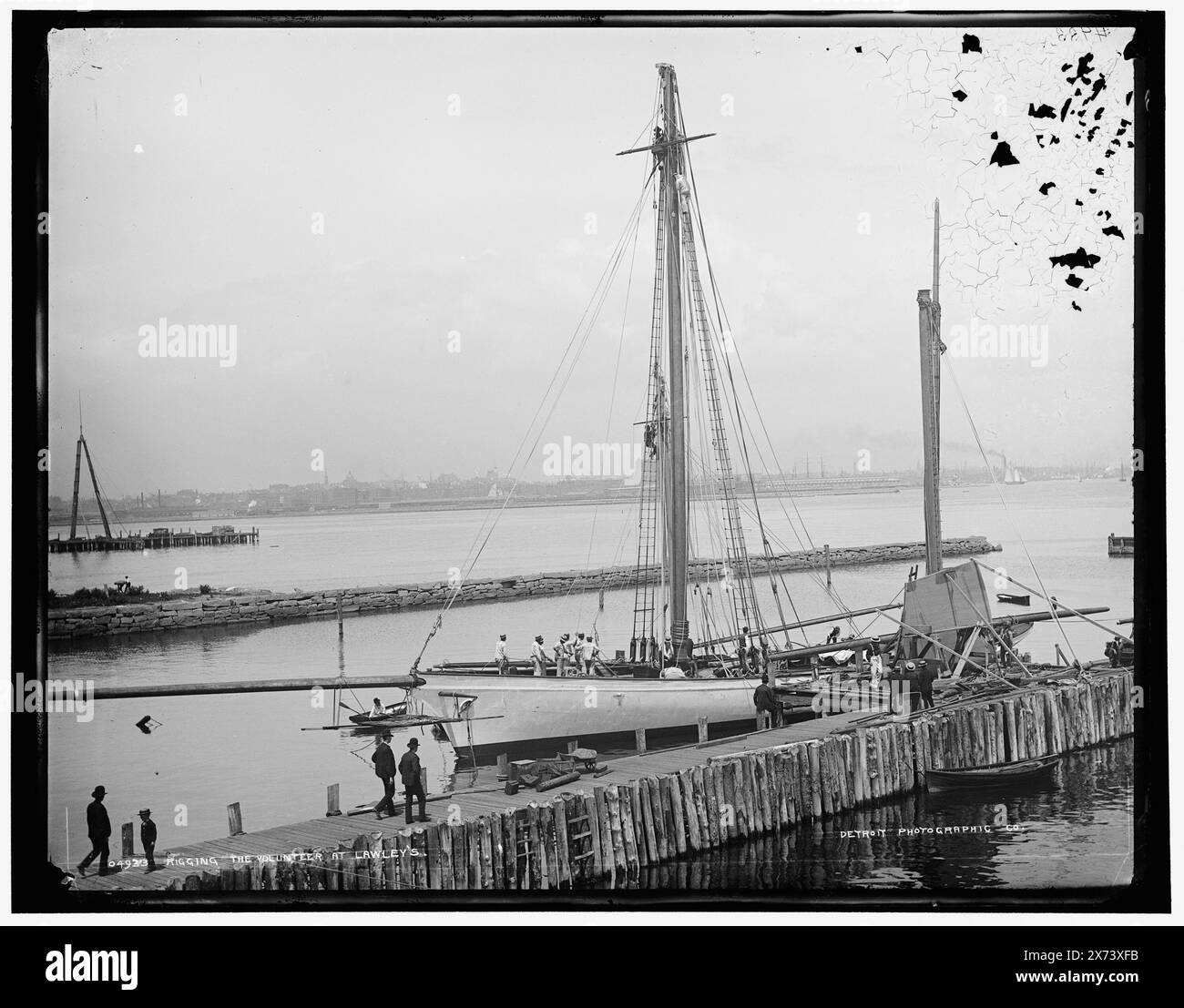 Rigging the Volunteer at Lawley's, Date Based on Detroit, Catalogue F (1899) e The Regging of the Volunteer nel 1891 presso il cantiere di Lawley a Boston. (Fonte: C. Seavey, 2020), Detroit Publishing Co. N. 04933., Gift; State Historical Society of Colorado; 1949, Volunteer (Yacht) , Lawley's.. , Yachts. , Moli e moli. , Stati Uniti, Massachusetts, Boston. Foto Stock