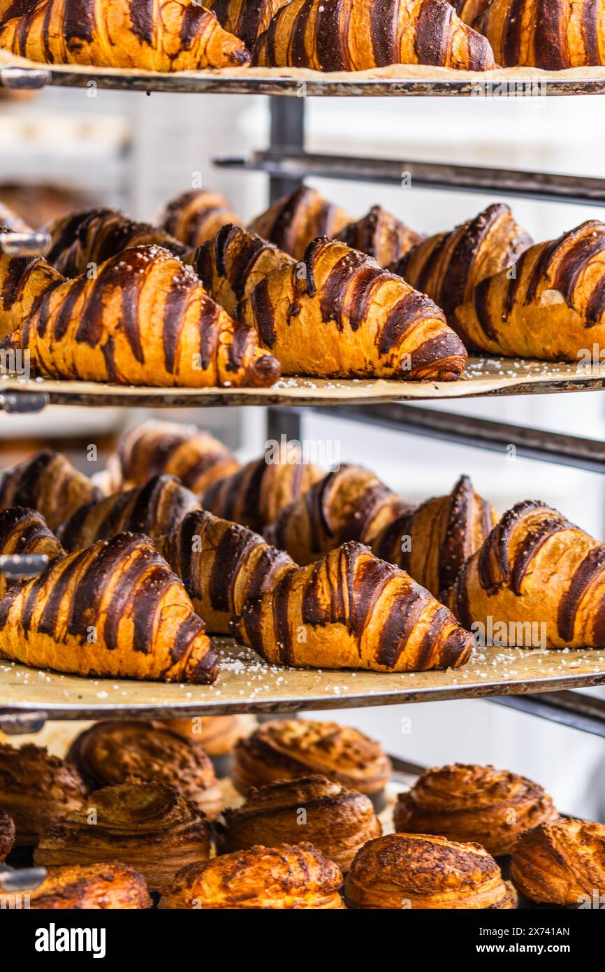 Croissant al cioccolato appena sfornati in un carrello in una panetteria Foto Stock