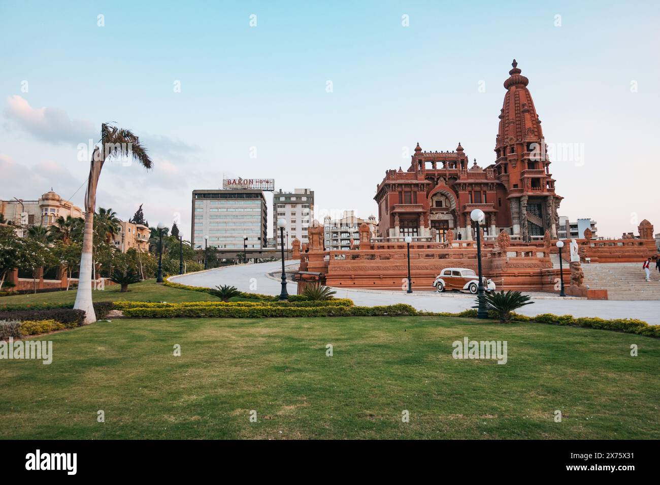Lo storico Palazzo del Barone Empain a Heliopolis, il Cairo, presenta la sua architettura unica di ispirazione indù, giardini lussureggianti e un'auto d'epoca Foto Stock