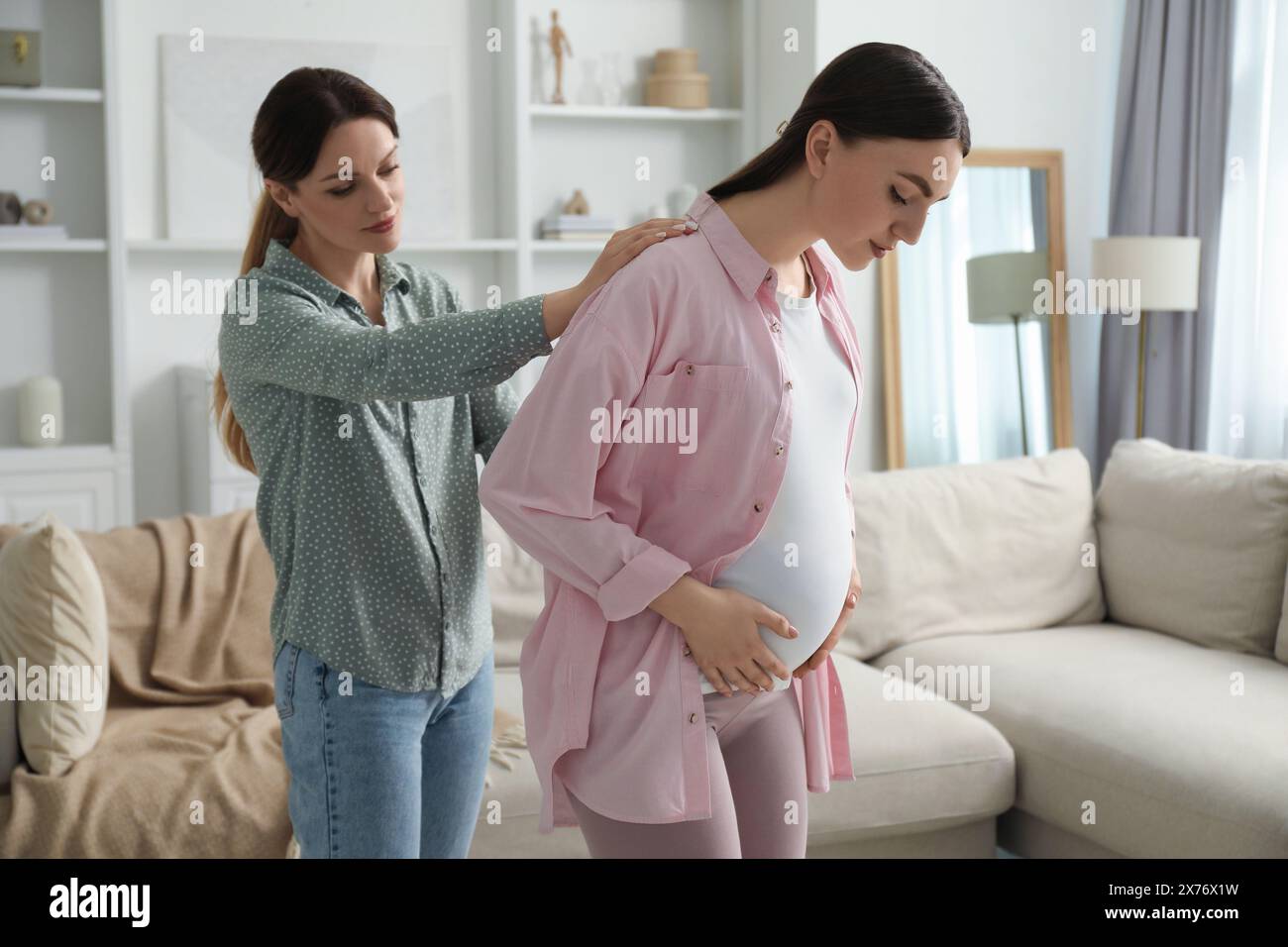 Doula massaggiava una donna incinta a casa. Preparazione alla nascita del bambino Foto Stock