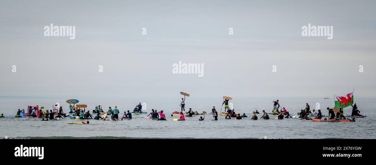 Le persone prendono parte a una pagaia a Caswell Bay a Swansea, parte di un evento nazionale organizzato dai surfisti contro le acque reflue, per chiedere la fine dell'inquinamento delle acque reflue e protestare contro le pratiche attuali di fognatura che entrano in mare. Foto Stock