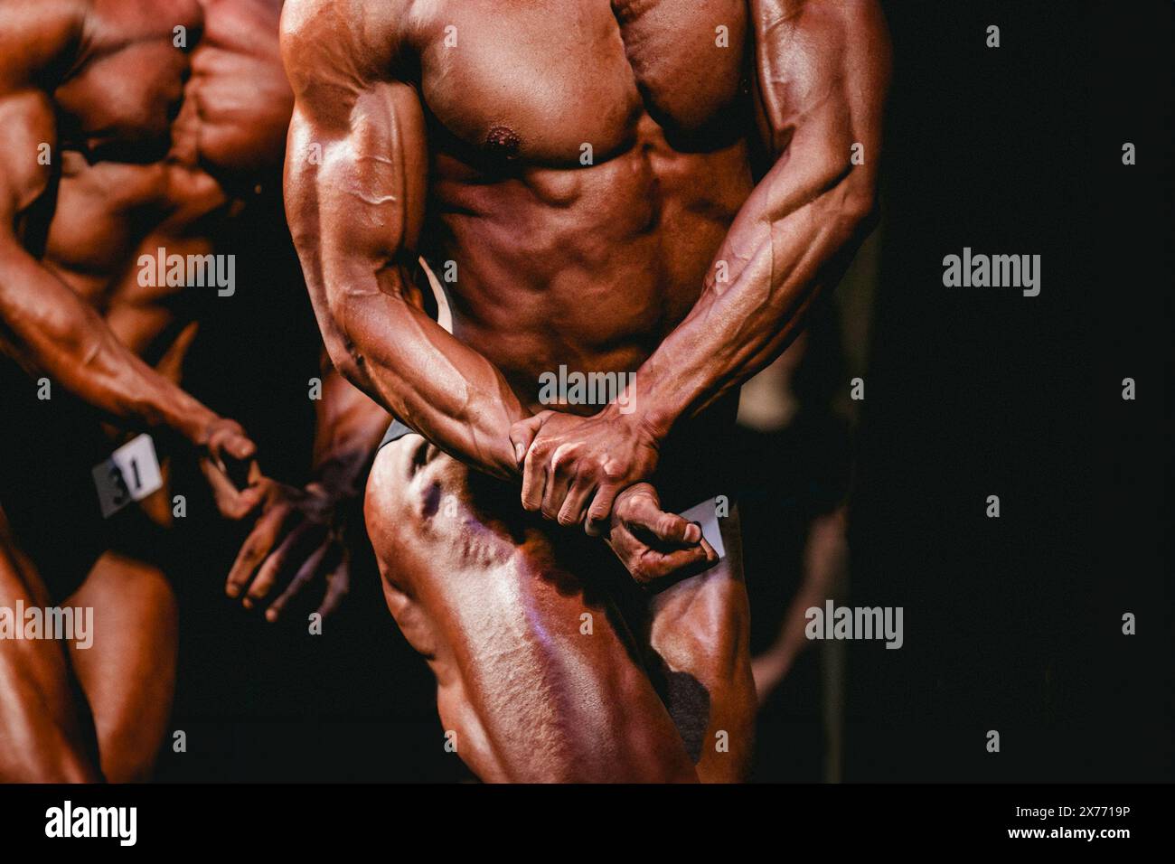 l'atleta di bodybuilding da competizione mostra la posa laterale del petto Foto Stock