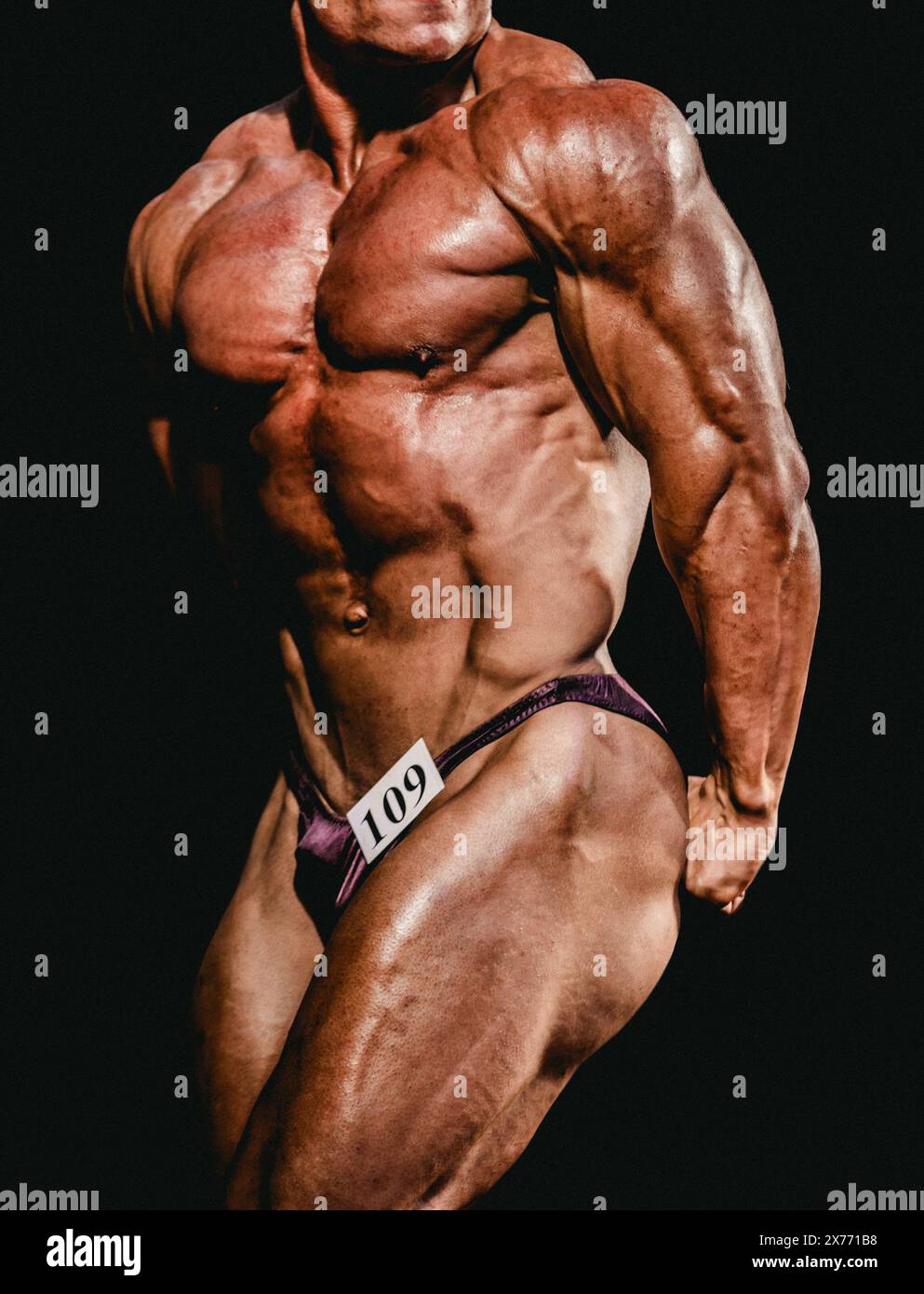 l'atleta bodybuilder mostra triceps laterali per le competizioni di bodybuilding Foto Stock