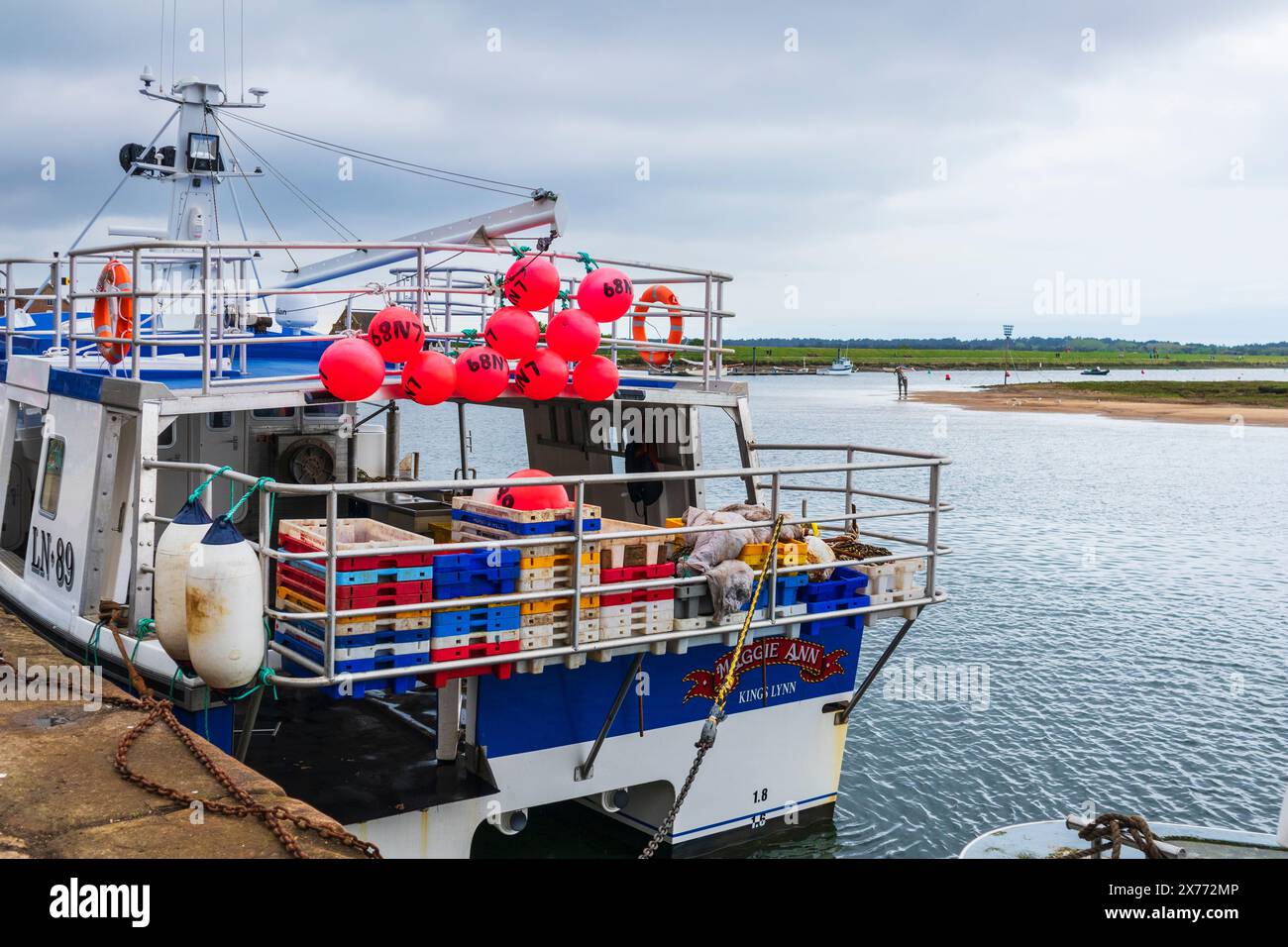 Grande imbarcazione da pesca ormeggiata a Wells-NEXT-the-Sea in una giornata di maggio con boe rosse e scatole di pesce rosa Foto Stock