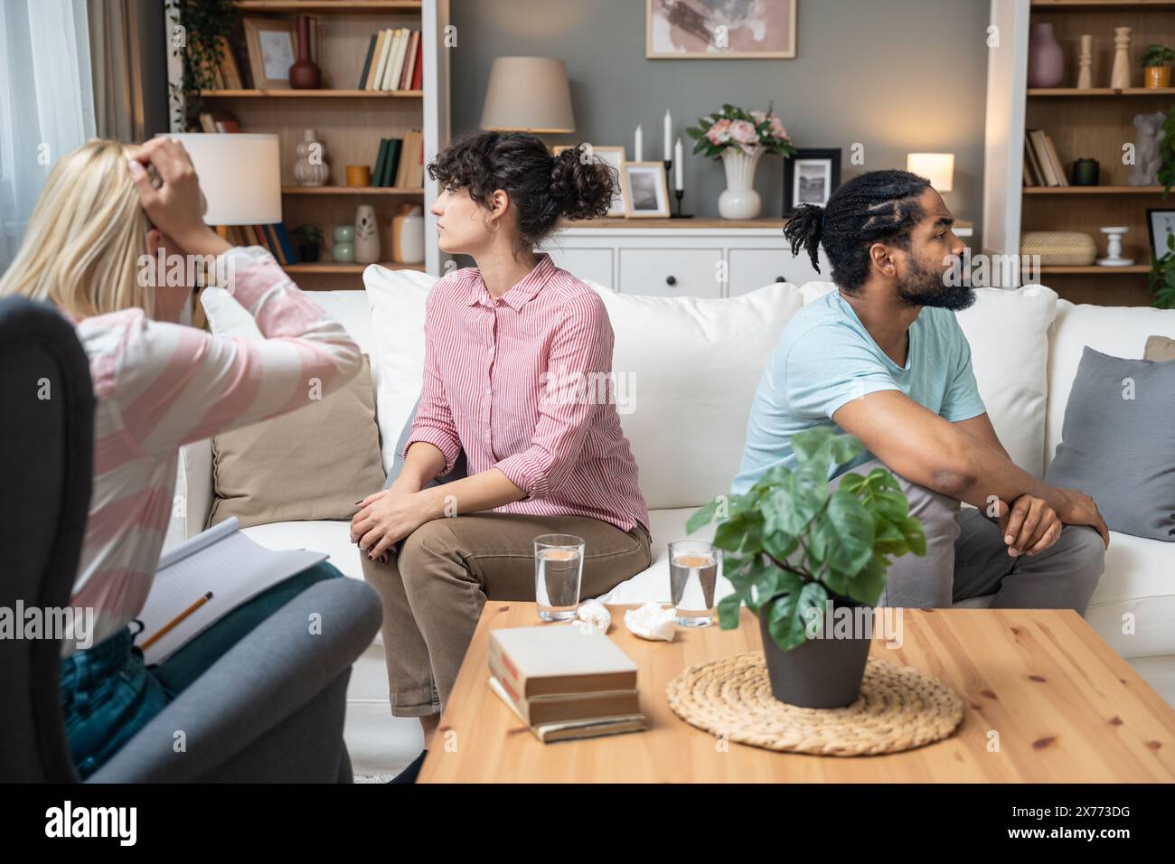 Giovani e donne seri che parlano con psicologo consulente si lamentano di cattive difficoltà di relazione tra marito e moglie. Una coppia di famiglie Foto Stock