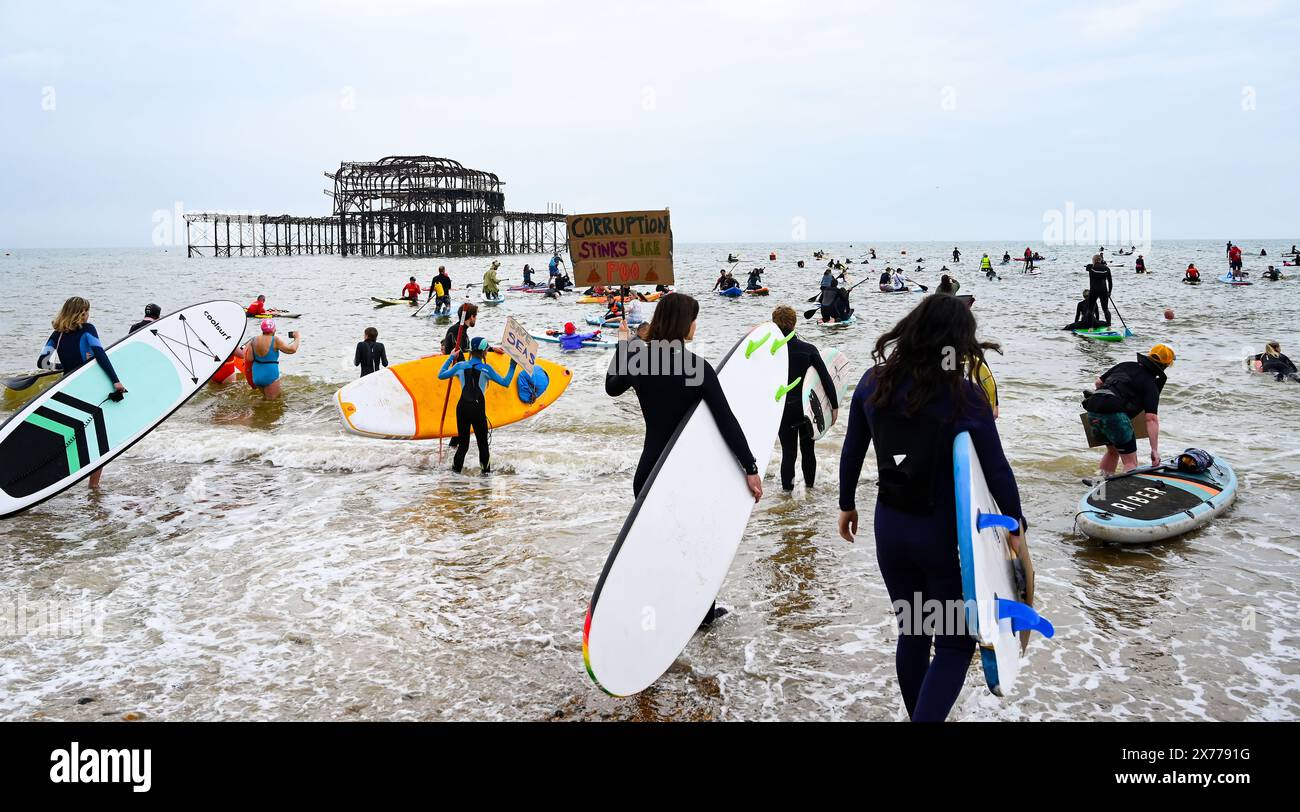 Brighton Regno Unito 18 maggio 2024 - la protesta contro le acque reflue di Brighton West Pier oggi, mentre centinaia di pagaie e nuotatori si recano in mare per fare campagna per le compagnie idriche affinché smettano di pompare acque reflue nel mare e nei corsi d'acqua intorno alla Gran Bretagna . Accreditamento Simon Dack / Alamy Live News Foto Stock