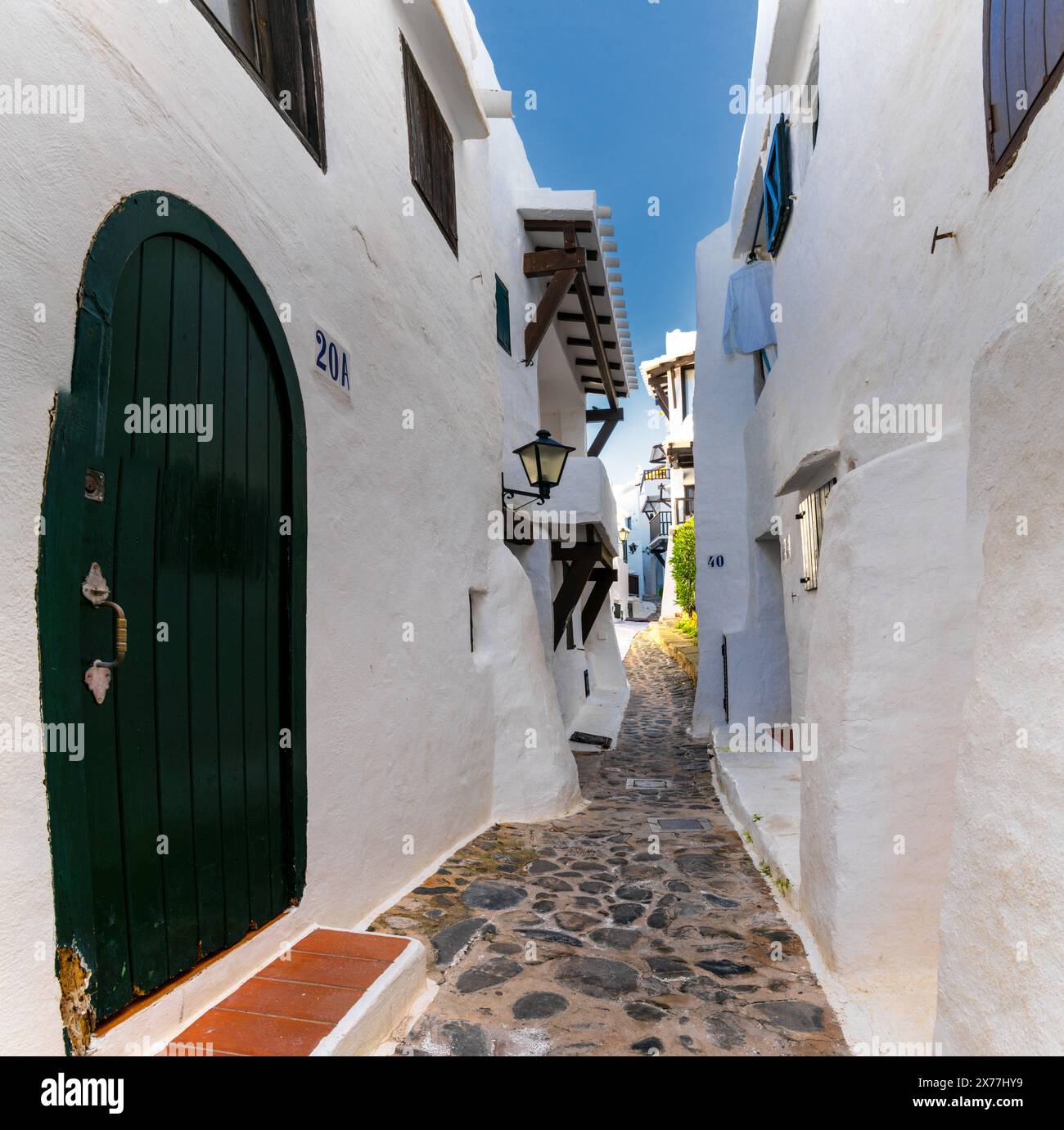Binibeca Vell, Spagna - 24 gennaio 2024: Vicolo stretto che conduce attraverso un labirinto di edifici imbiancati nel centro del villaggio di Binibeca Vell Foto Stock