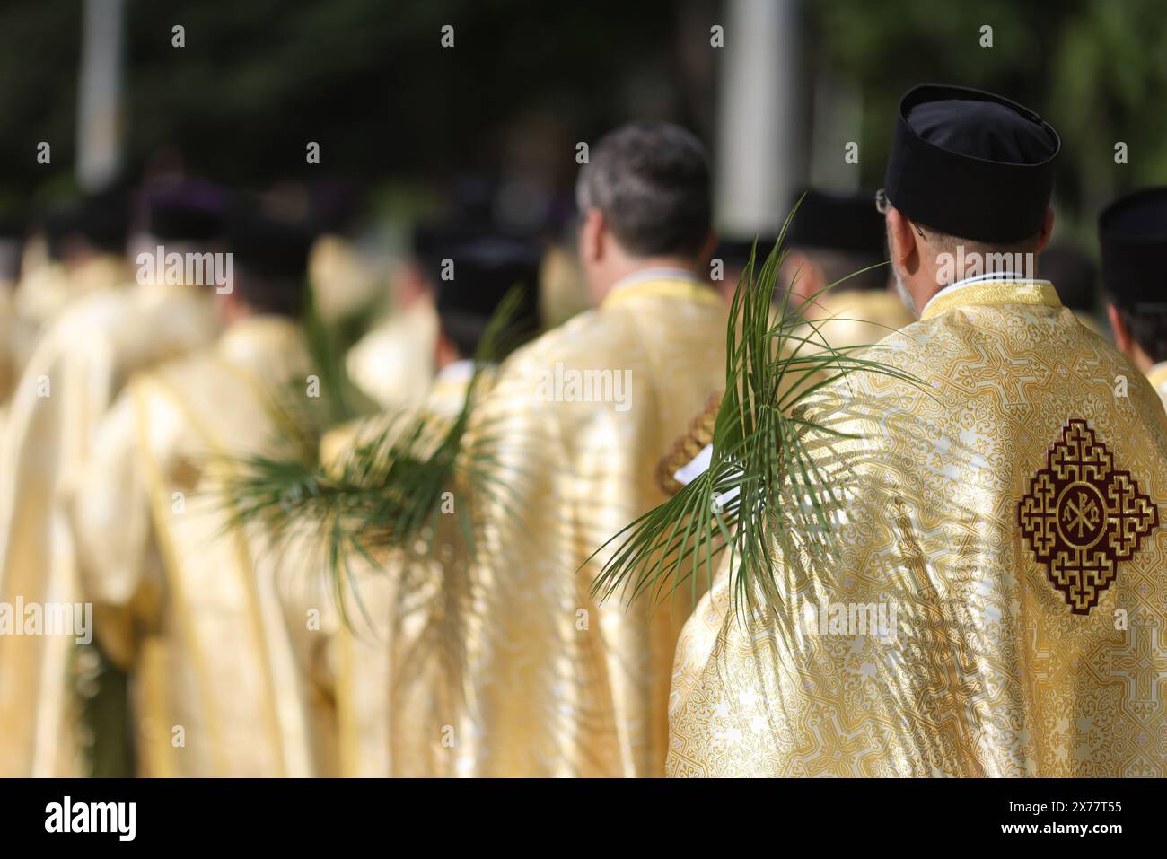 I sacerdoti ortodossi rumeni che tengono le foglie di palma camminano per le strade di Bucarest durante una processione di pellegrinaggio della domenica delle Palme. Foto Stock