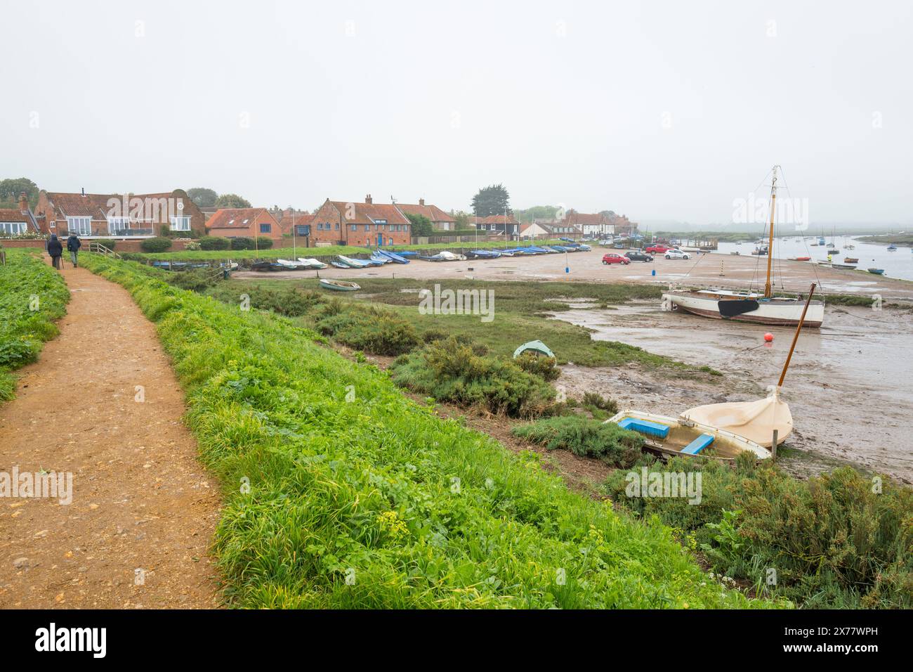 Burnham Overy Staithe con la bassa marea in una giornata fredda e ricoperta di piccole imbarcazioni ormeggiate sulla riva fangosa. Foto Stock