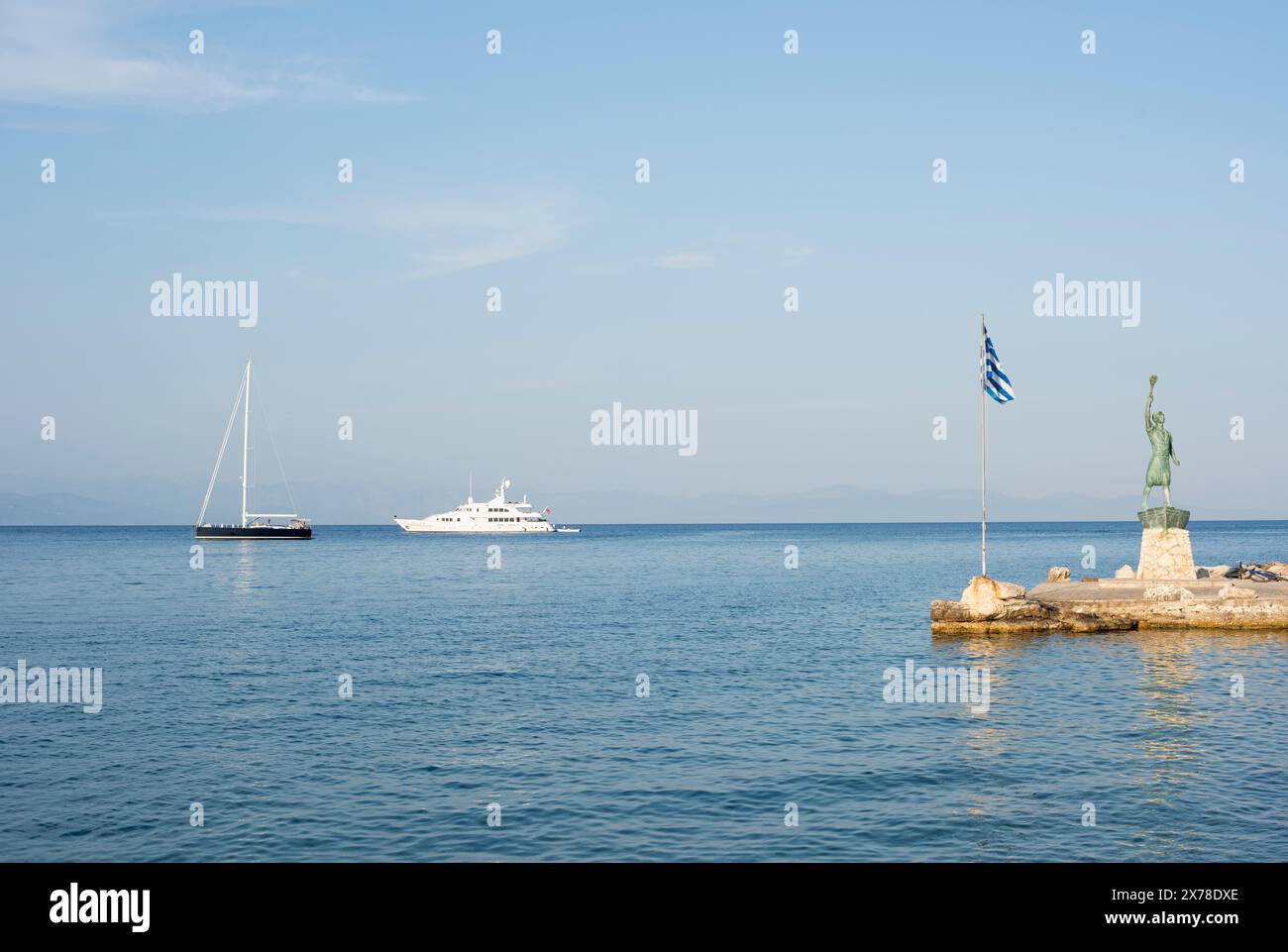 Statua del porto di Gaios sull'isola di Paxos in Grecia, sullo sfondo di barche e barche a vela che navigano nel Mar Mediterraneo Foto Stock