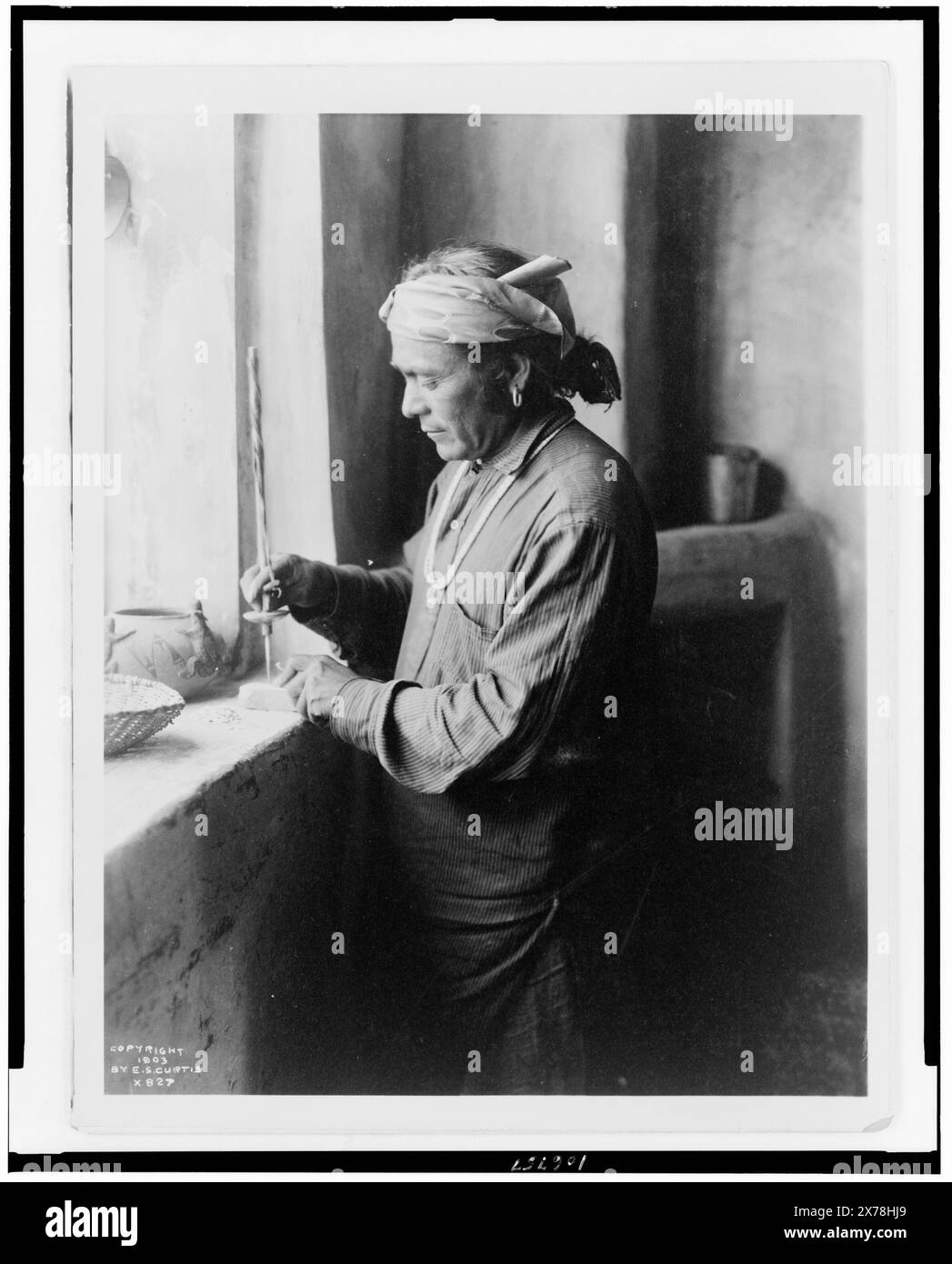 Operaio di perle indiano Zuni che praticano fori in perline, Edward S. Curtis Collection., Curtis n. 827.. Indians of North America, New Mexico, Zuni, Arts & Crafts, 1900-1910. , Zuni Indians, Arts & Crafts, 1900-1910. Foto Stock