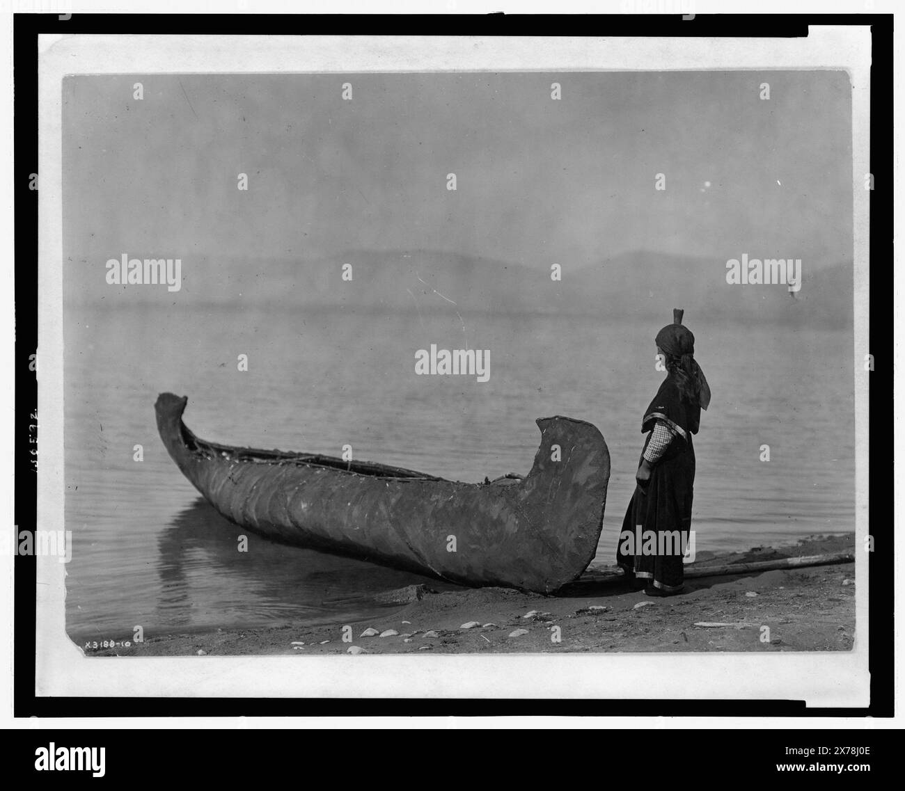 Sulla riva del lago Kutenai, titolo dall'articolo, Curtis no 3188-10., Forms part of: Edward S. Curtis Collection ., pubblicato in: The North American Indian / Edward S. Curtis. [Seattle, Washington.] : Edward S. Curtis, 1907-30, Suppl. v. 7, pl. 251., WSUNA. Indiani del Nord America, 1910. , Indiani Kootenai, 1910. , Canoes, 1910. Foto Stock