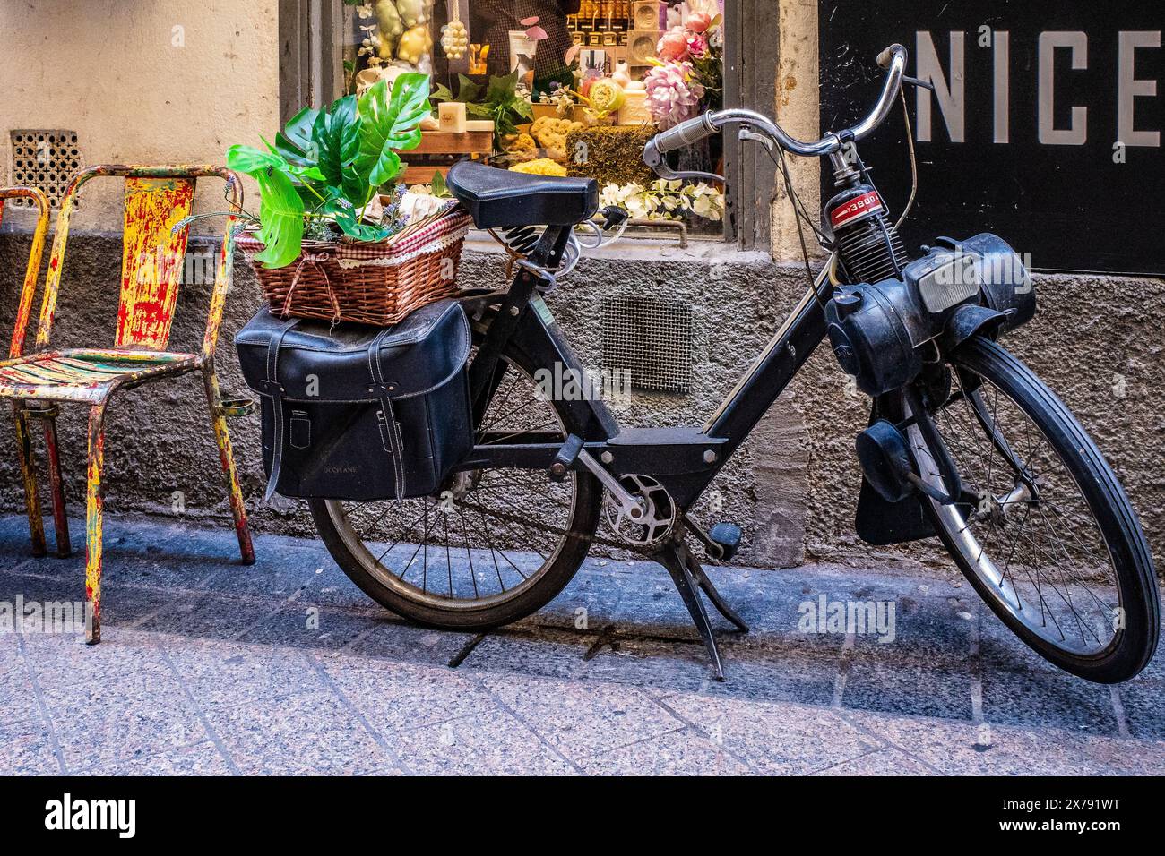 Nizza, Francia - bicicletta con cesto di fiori in una strada della città vecchia, Nizza, Provenza. Tradizionale scena di strada francese. Bicicletta a motore Foto Stock