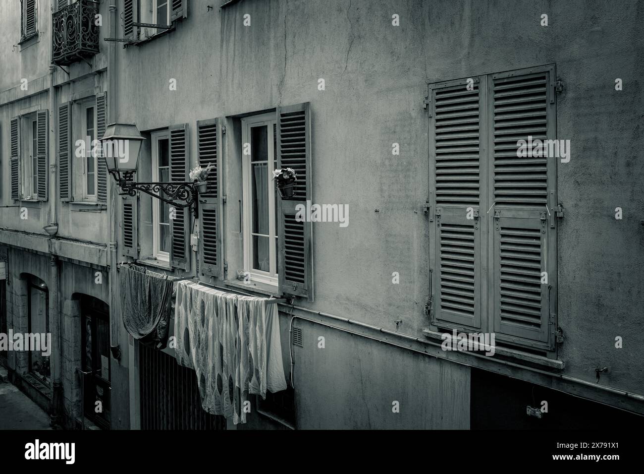 Tradizionale facciata di appartamenti su una strada nella città vecchia, Vieille Ville a Nizza, Costa Azzurra, Sud della Francia. Tipico stile di vita francese. BIANCO E NERO Foto Stock