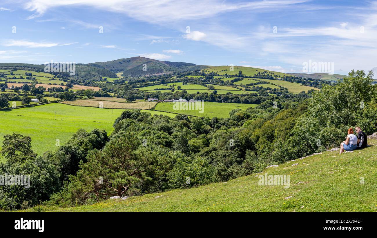 Un panorama multi-immagine di una giovane coppia che si gode la vista sul fiume Alyn verso Moel Famau dal Loggerheads Country Park catturato il 17 luglio 20 Foto Stock