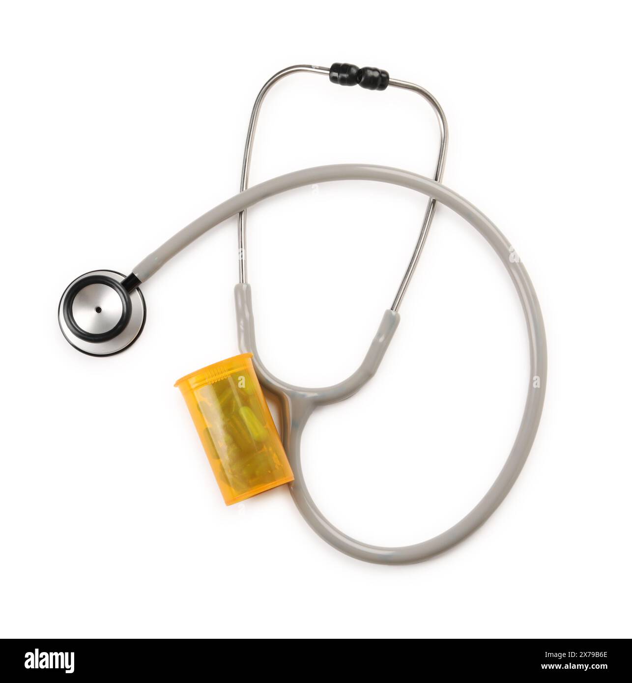 Stetoscopio e contenitore con pillole isolate su bianco, vista dall'alto. Strumento medico Foto Stock