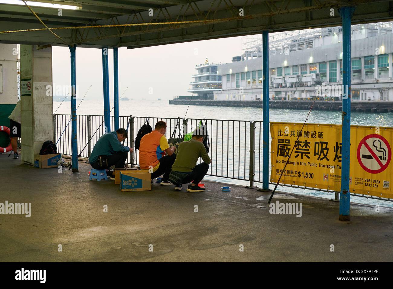 HONG KONG, CINA - 5 DICEMBRE 2023: Gente che pesca a Tsim Sha Tsui a Hong Kong. Foto Stock