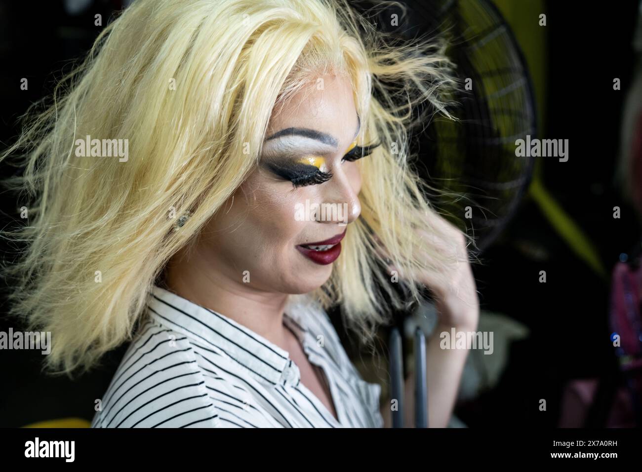 Thailandia. 18 maggio 2024. Una drag queen raddrizza i capelli davanti a un grande fan dietro le quinte prima dello spettacolo. Le drag queen e i fan danno il benvenuto all'arrivo di Nymphia Wind, il più recente vincitore del franchise di RuPaul's Drag Race, e il primo artista del sud-est asiatico a vincere la corona in oltre un decennio, allo Stranger Bar di Bangkok, Thailandia. Crediti: Matt Hunt/Neato/Alamy Live News Foto Stock