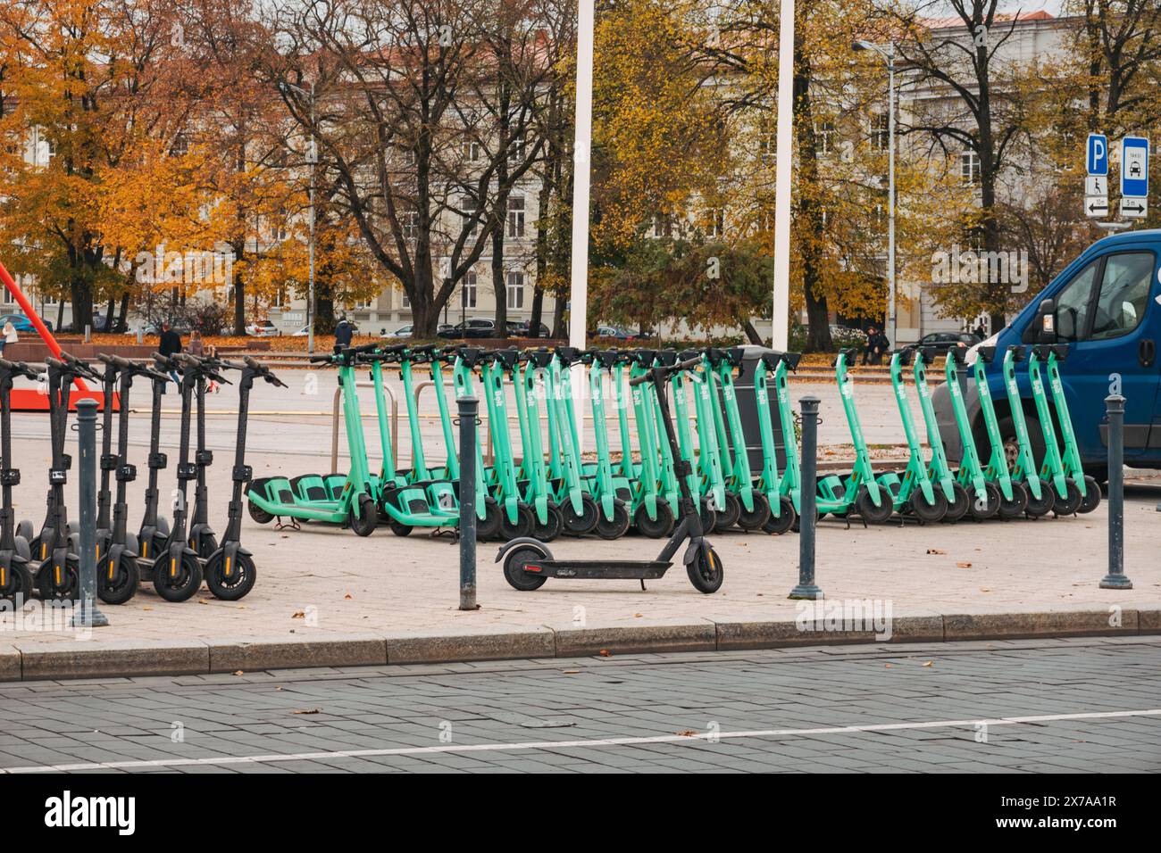 File di scooter elettrici parcheggiati e pronti per il noleggio a Vilnius, Lituania. Gli utenti pagano e sbloccano per loro tramite l'app mobile Bolt Foto Stock
