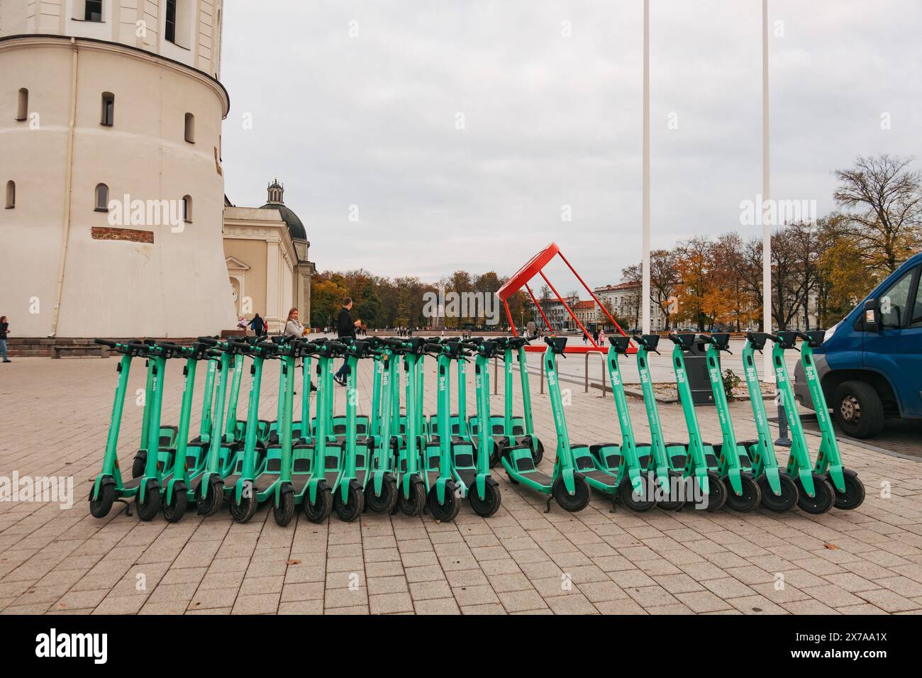 File di scooter elettrici parcheggiati e pronti per il noleggio a Vilnius, Lituania. Gli utenti pagano e sbloccano per loro tramite l'app mobile Bolt Foto Stock