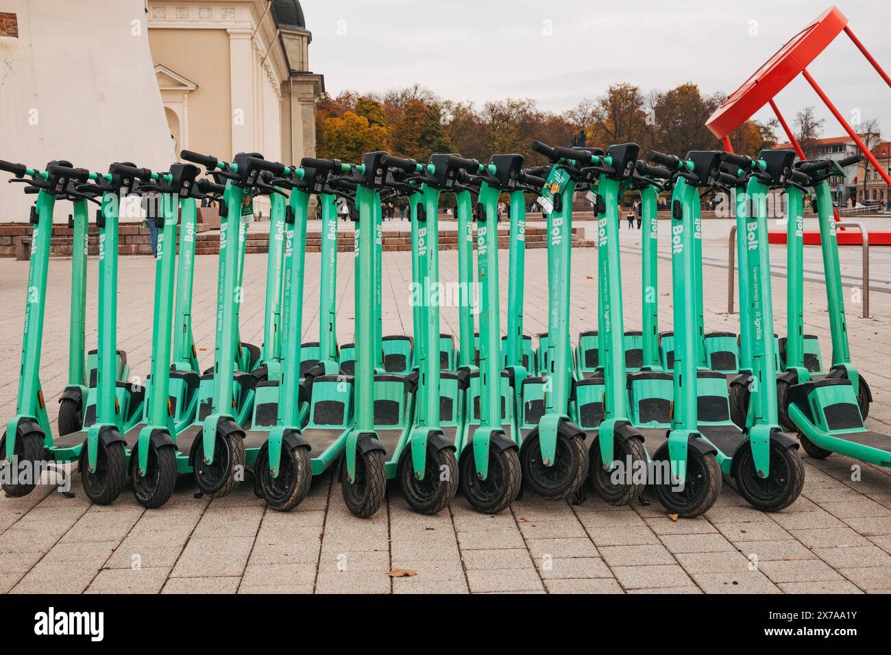 File di scooter elettrici parcheggiati e pronti per il noleggio a Vilnius, Lituania. Gli utenti pagano e sbloccano per loro tramite l'app mobile Bolt Foto Stock