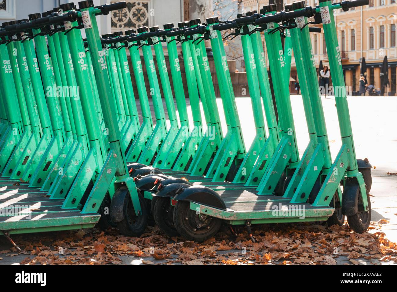 File di scooter elettrici Bolt parcheggiati e pronti per il noleggio a Kaunas, Lituania. Gli utenti aprono un'app sul loro telefono per sbloccarla e giocarci Foto Stock