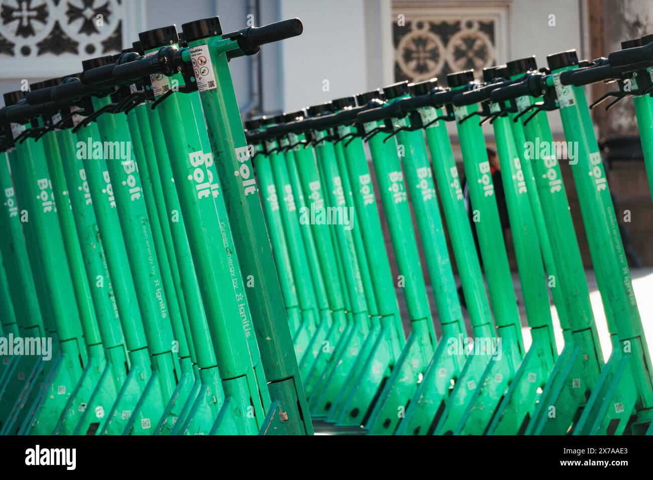 File di scooter elettrici Bolt parcheggiati e pronti per il noleggio a Kaunas, Lituania. Gli utenti aprono un'app sul loro telefono per sbloccarla e giocarci Foto Stock
