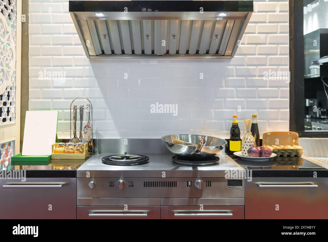 Foto interna di una cucina moderna. Con un'elegante stufa, un lavandino elegante e una sofisticata cappa di scarico, questo spazio incarna la fusione perfetta Foto Stock