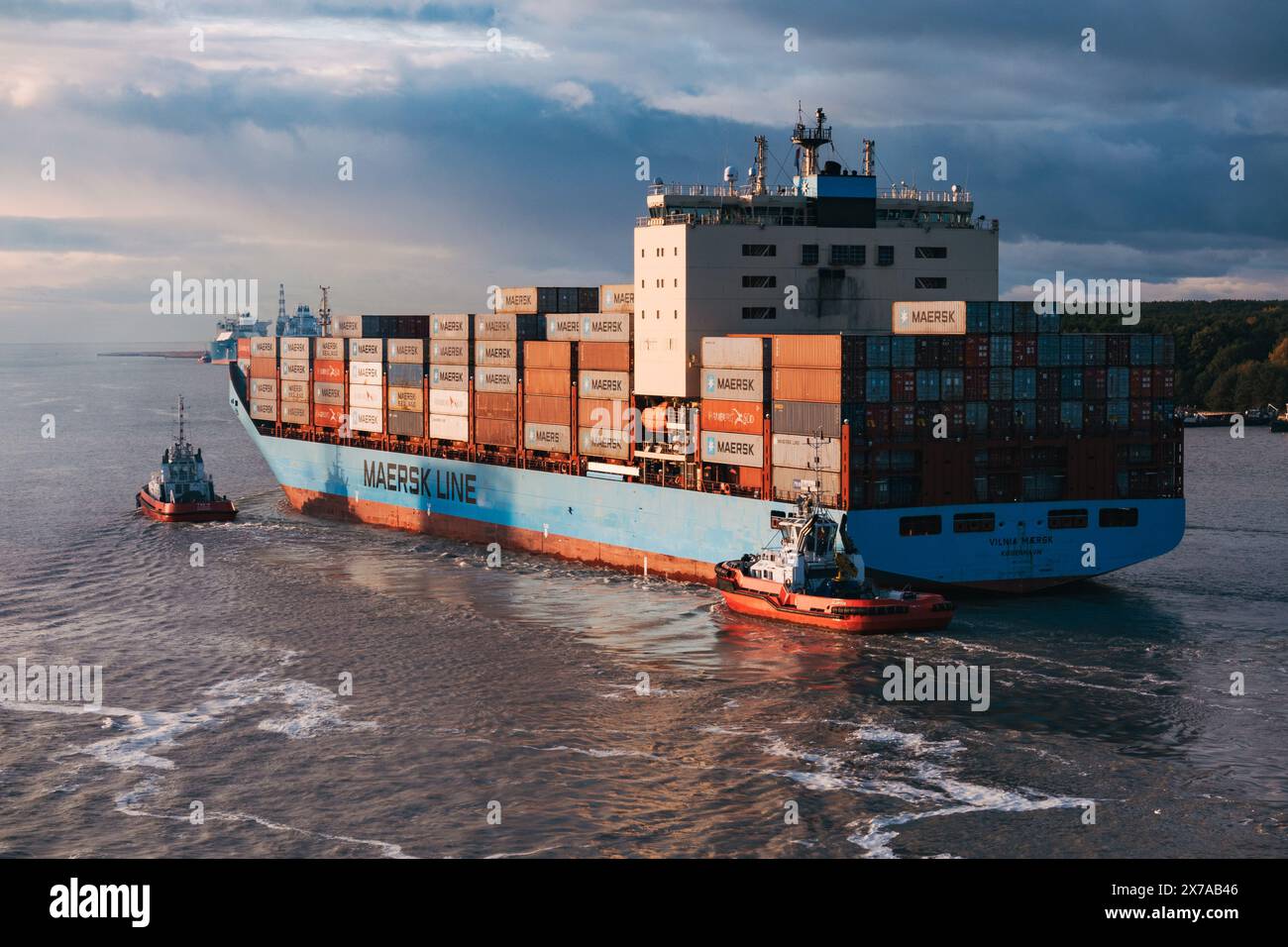 La nave portacontainer Vilnia Maersk è guidata nel porto di Klaipeda da con rimorchiatori in una mattinata d'autunno soleggiata ma tranquilla, in Lituania Foto Stock