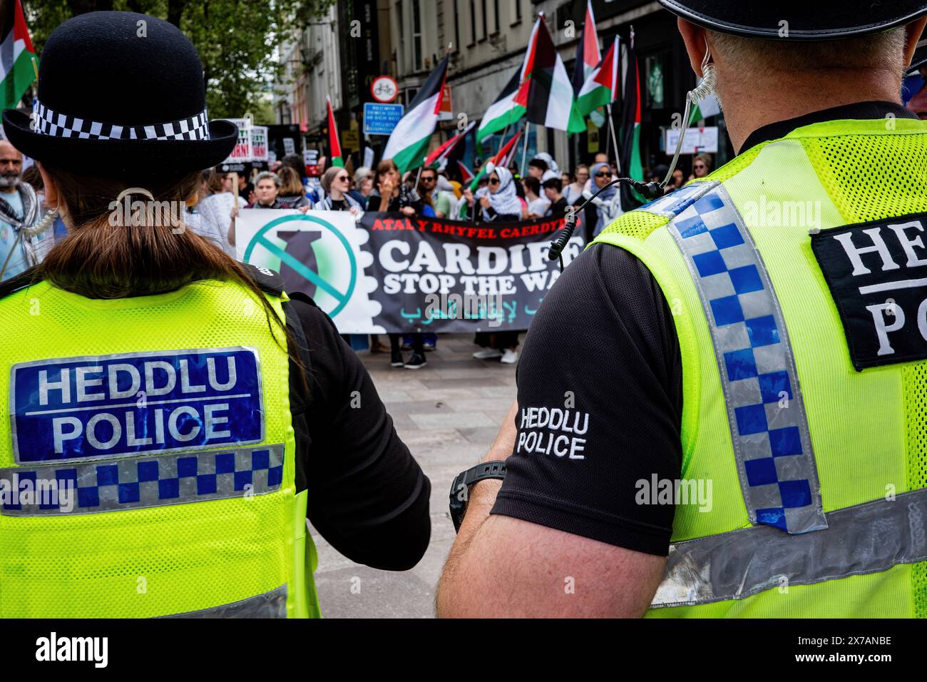 Due agenti di polizia che guardano un manifestante pro-palestinese in una manifestazione di strada anti-Israele - campagna di solidarietà palestinese. Centro di Cardiff. Foto Stock