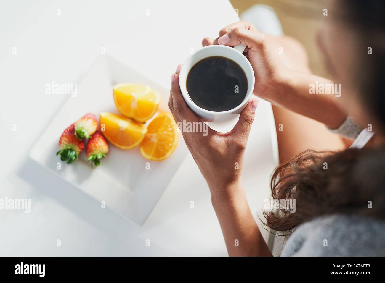 Caffè, frutta e sopra persona con colazione al mattino per i benefici della nutrizione nella dieta. Sano, cibo e donna bere espresso sul tavolo in casa Foto Stock