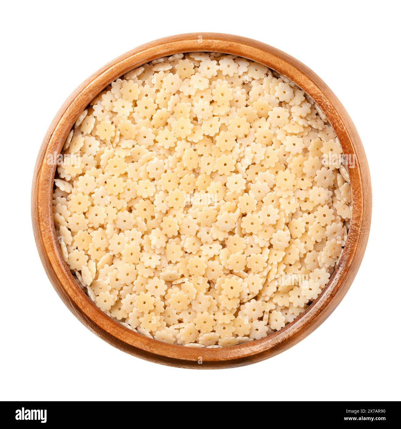 Stelle o stelline, pasta e zuppa italiana in un recipiente di legno. Pasta minima di semola di grano duro crudo. Piccole stelle con buco al centro. Foto Stock